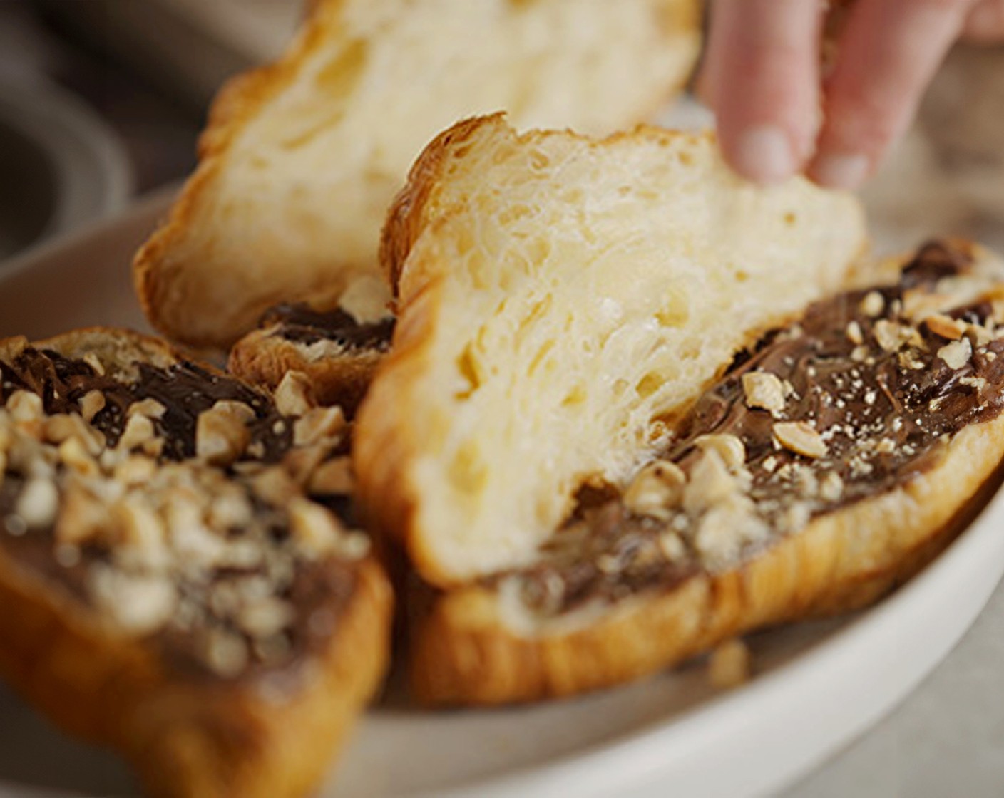 step 3 Sprinkle some of the hazelnuts (40 g) and blond chocolate (40 g) on top of the crème. Close each croissant to serve.