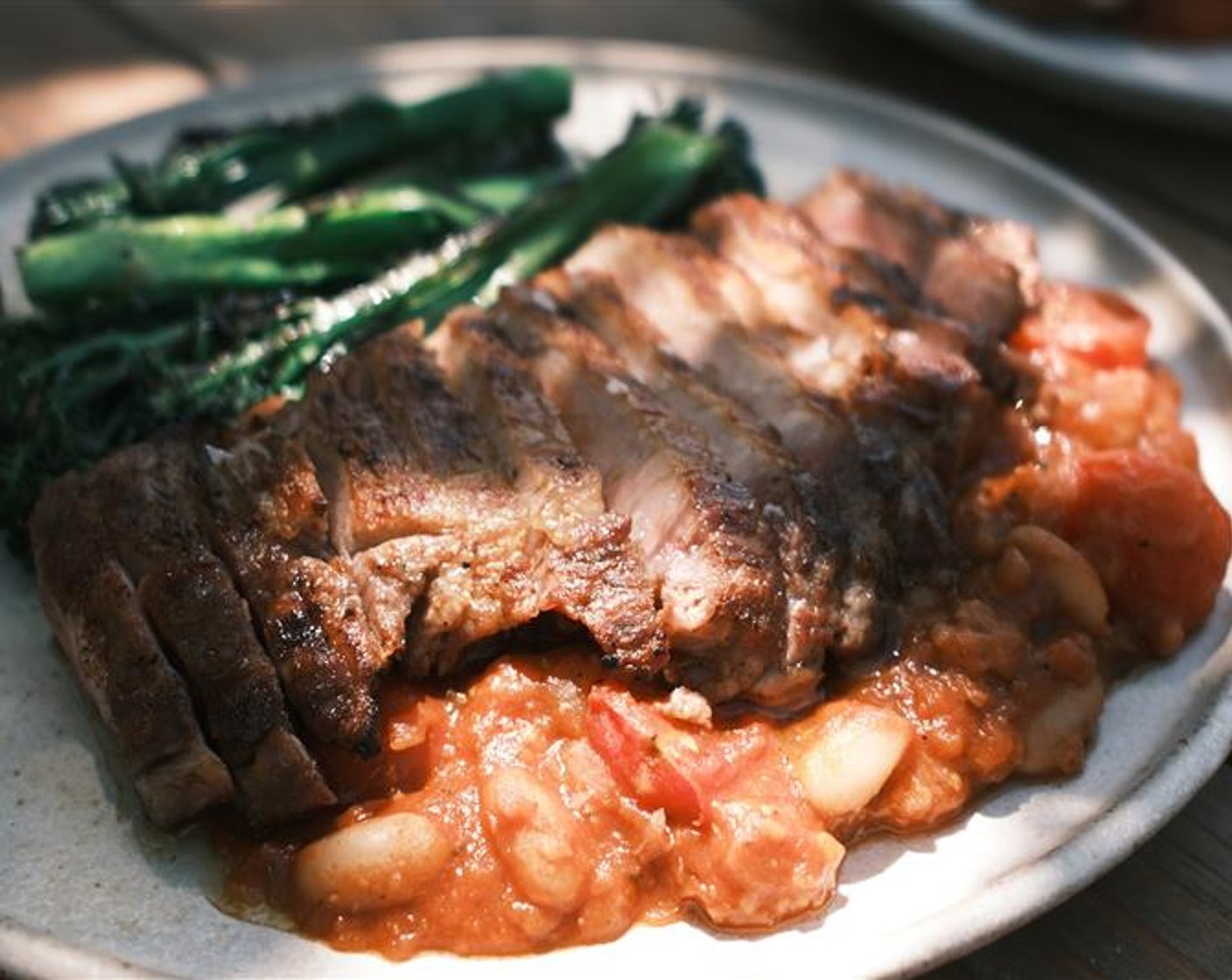 step 7 Spoon the beans onto two serving plates. Carve the pork steaks into thick slices and lay on top of the beans. Serve the charred broccoli alongside.