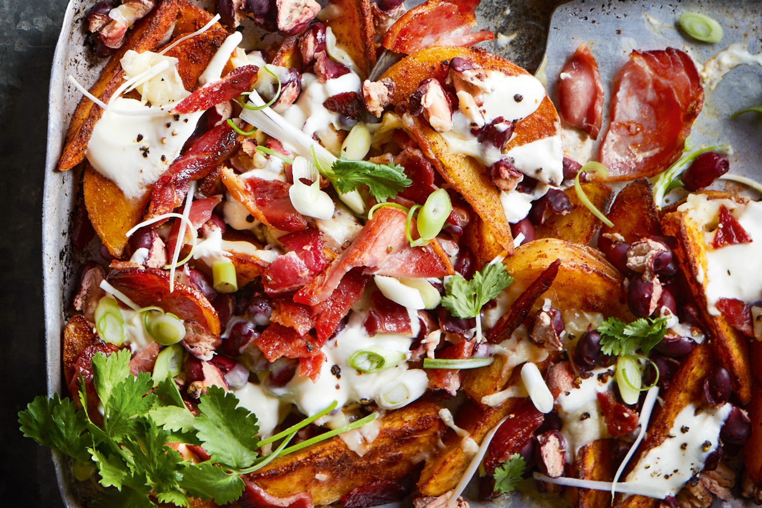 Loaded potato wedges with beans, bacon and cheese