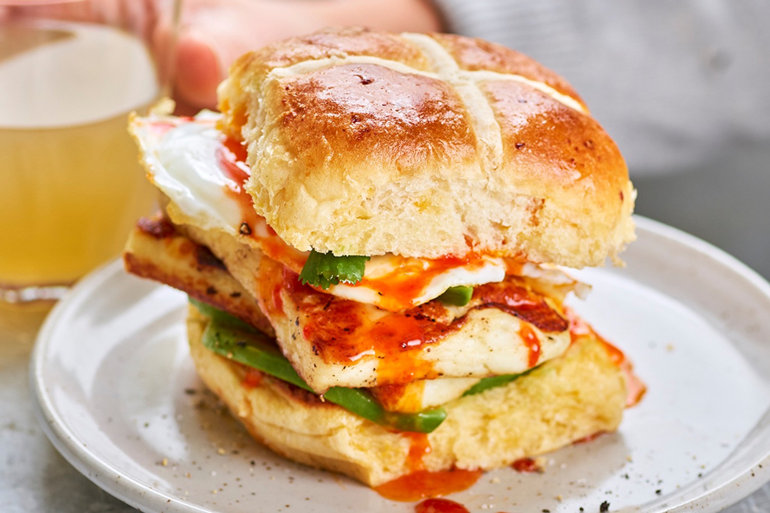 Sweet chilli halloumi, fried egg and avocado hot cross bun sandwiches
