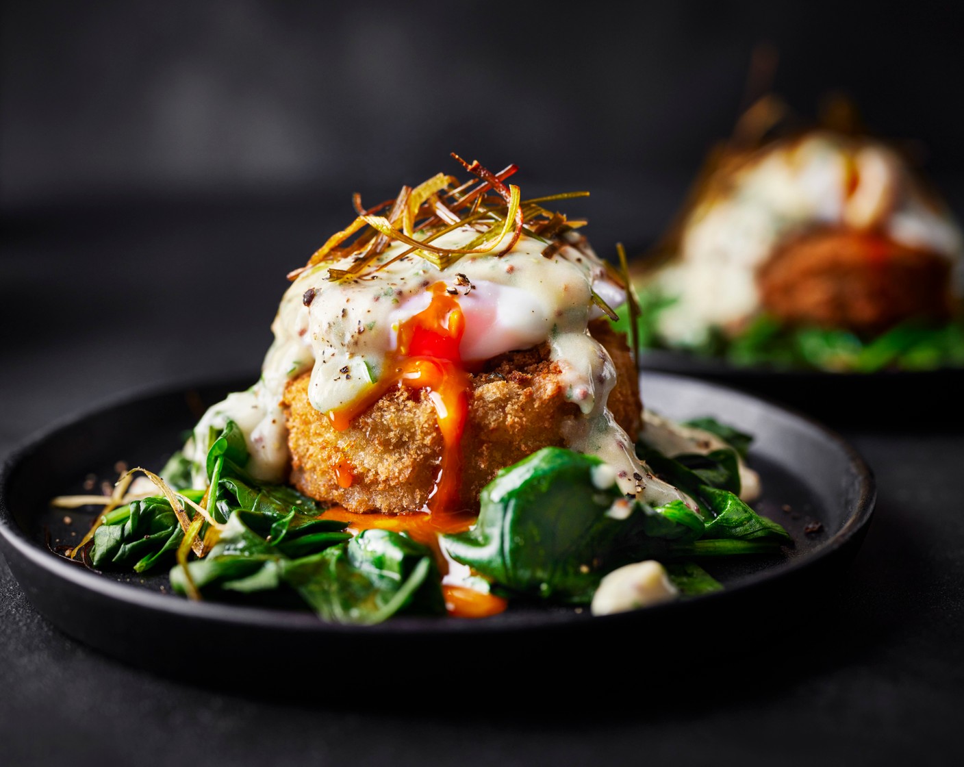 step 7 Serve the cakes on a bed of spinach and top with the poached eggs. Pour over the parsley sauce and top with the crispy leeks.