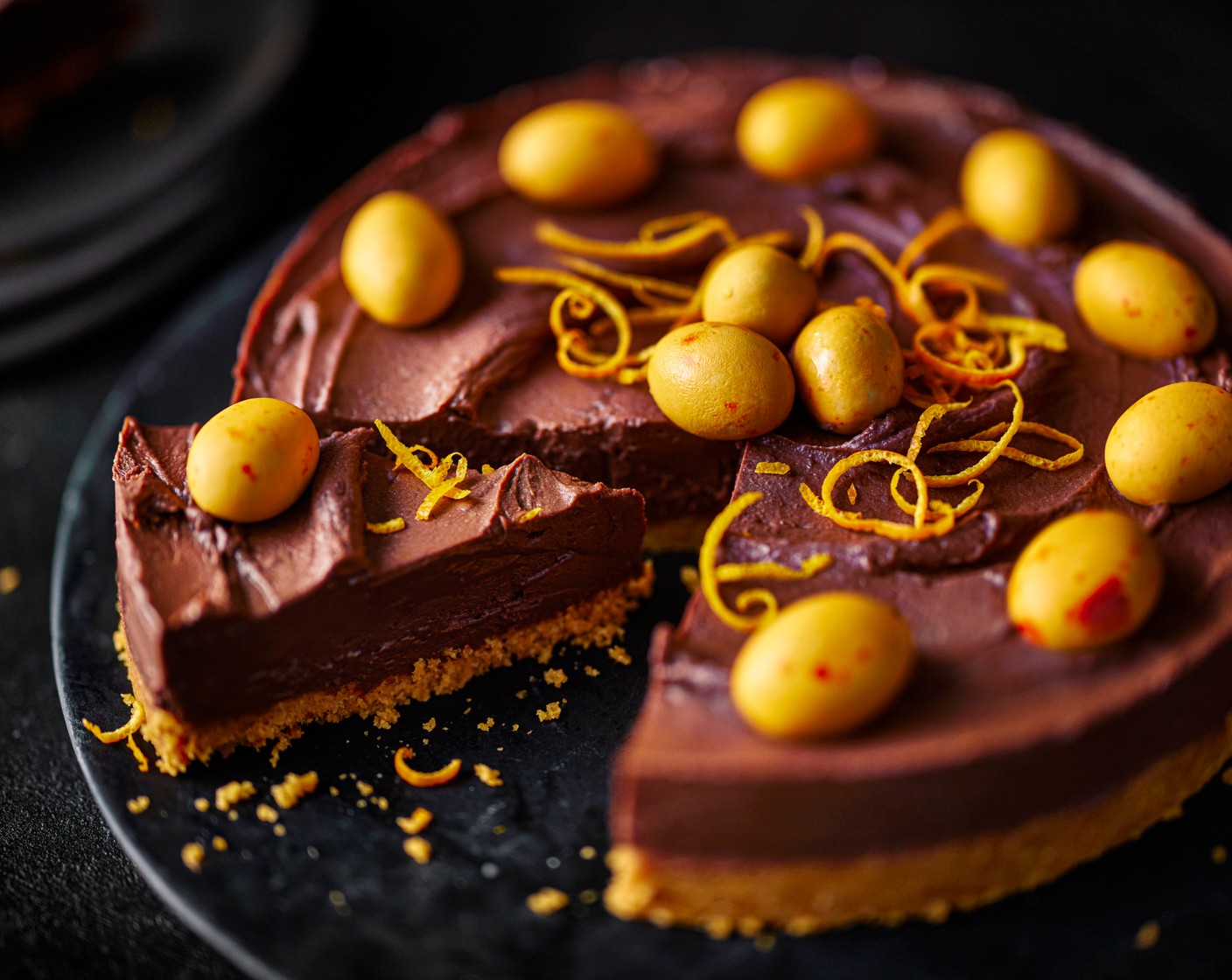 step 7 Decorate with the speckled eggs (90 g) in a circle pattern around the cheesecake, and the zest from the remaining orange (1).