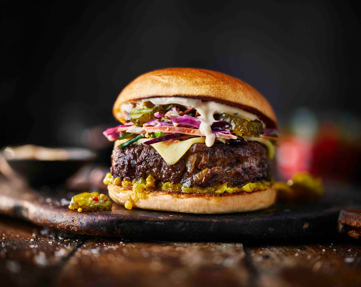 step 5 Spread the base of each toasted bun (4) with the house burger pickle (2 tbsp). Top with a cheeseburger, followed by fiery pickles (4 tbsp) and a generous spoonful of rainbow slaw. Add the lids, secure with a skewer if you like, and serve straight away with chips or French fries.