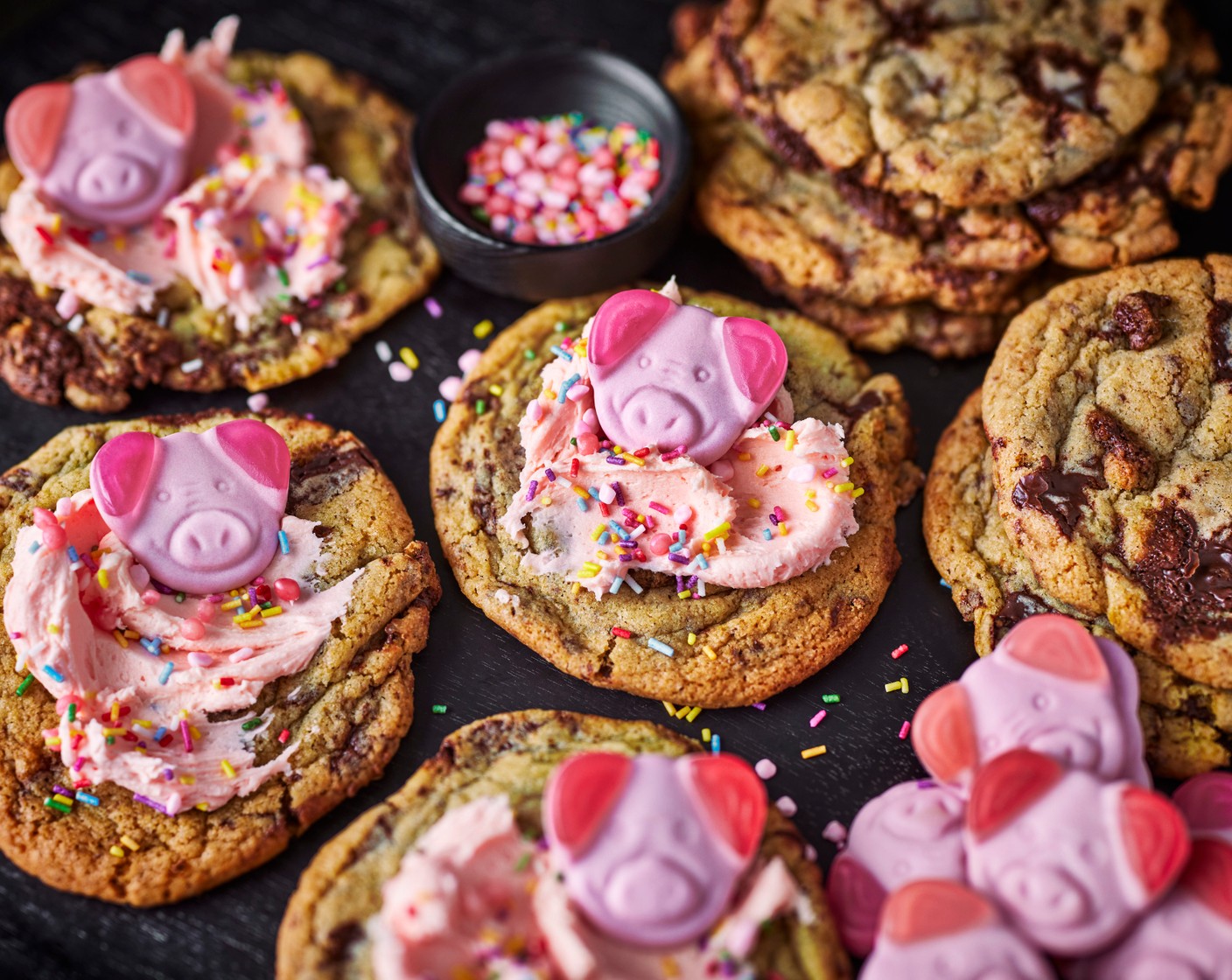 step 9 Once the cookies have cooled, begin decorating. Add a dollop of icing to each cookie and smooth down with the back of a spoon. Sprinkle over the Percy pig sprinkles (as needed) with as much as you’d like and top each cookie with a Percy pig (as needed).