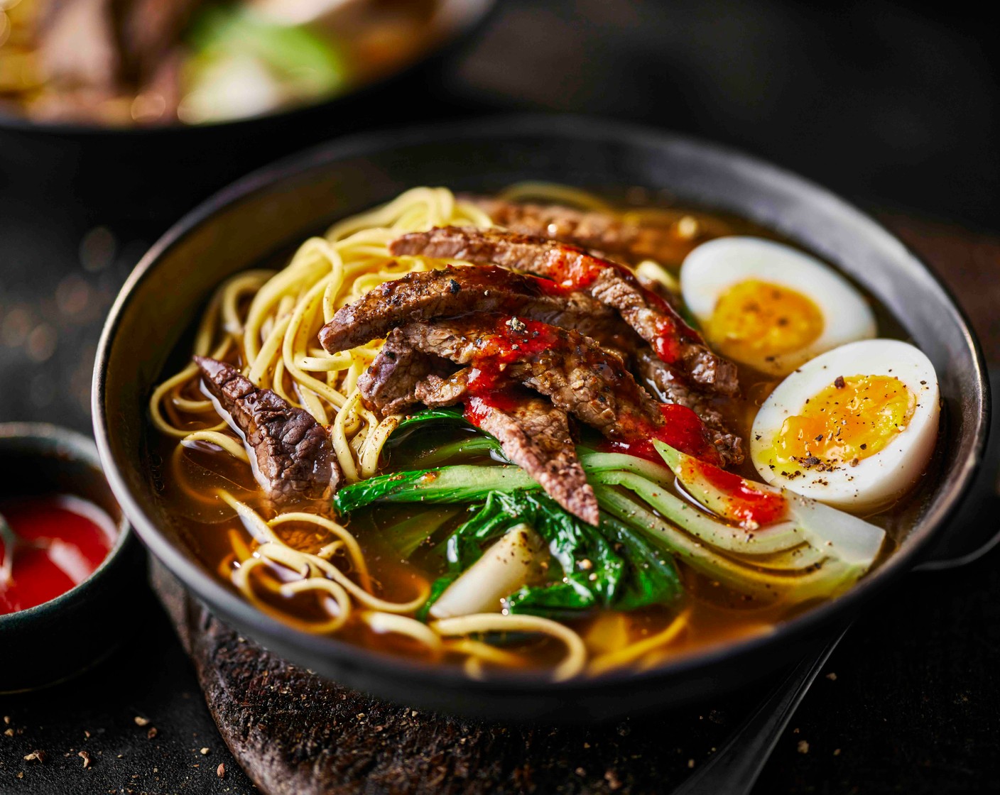 step 5 Peel and halve the eggs. Divide the noodles between serving bowls and top with the beef. Ladle over the broth and pak choi, then finish with the eggs and a drizzle of the remaining M&S toasted sesame oil (1 tbsp), plus a drizzle of M&S sriracha sauce (as needed), if you like.