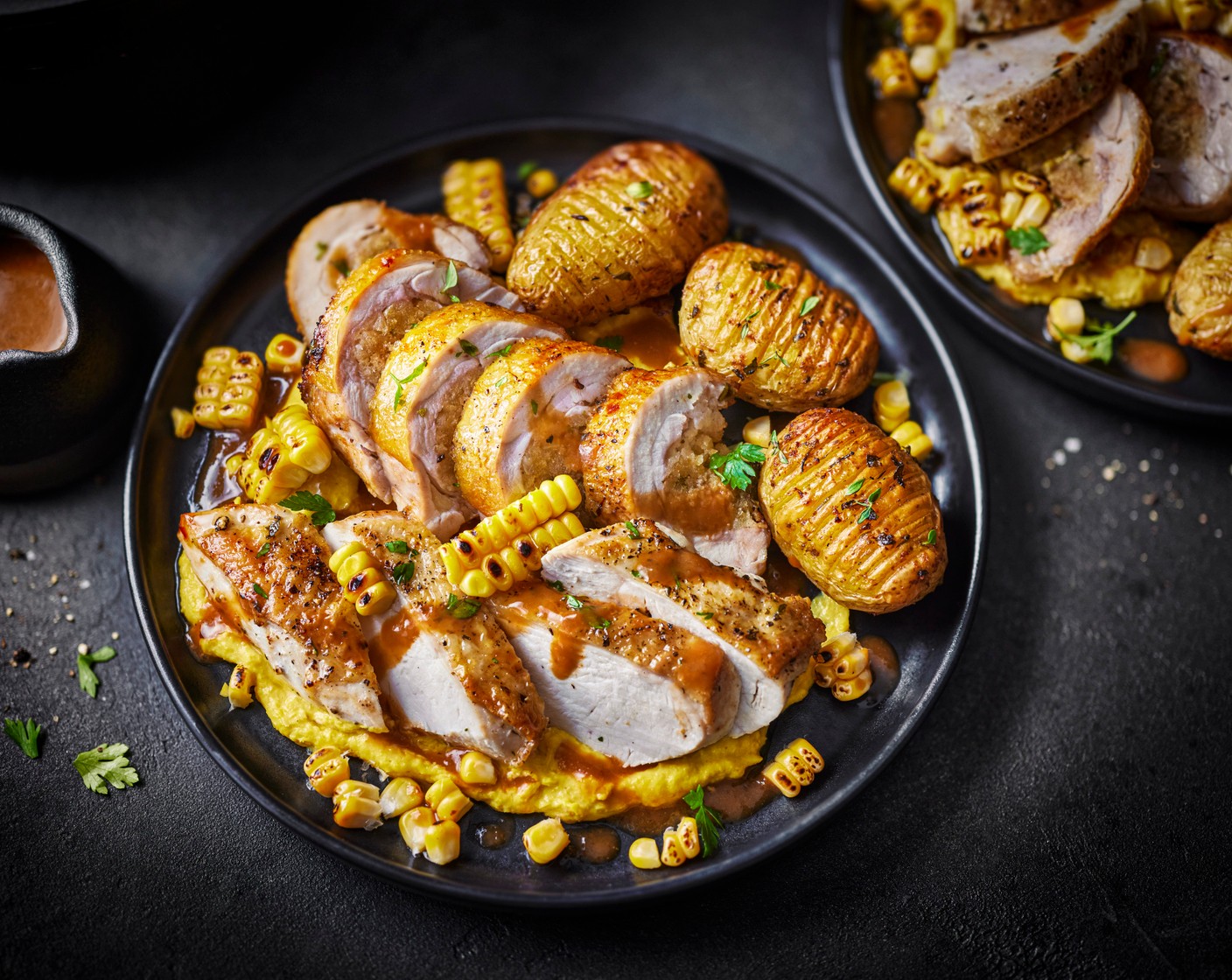 step 10 To serve, slice the ballotine and pan-roasted chicken breast, arrange on plates alongside the crispy hasselback potatoes, spoon over the sweetcorn purée and scatter with the charred corn kernels. Finish with a drizzle of red wine sauce.