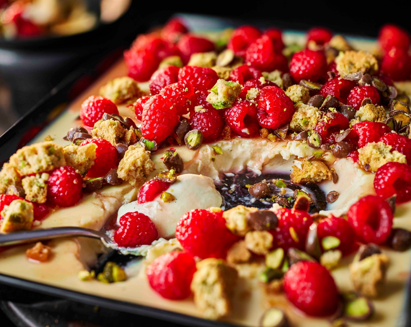 step 7 Scatter the fresh raspberries over the panna cotta, then scatter over the pistachio and almond cookies (100 g) followed by the pistachios (30 g).