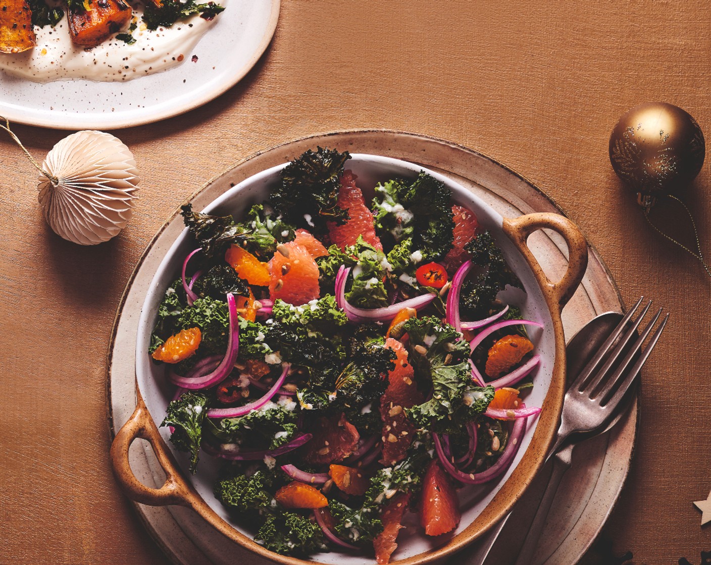 step 5 To build the salad, tumble the massaged kale onto a platter. Top with the grapefruit (1), clementine (2), crispy kale, onion and chilli before finishing with the remaining dressing and the mixed seeds (2 tsp).