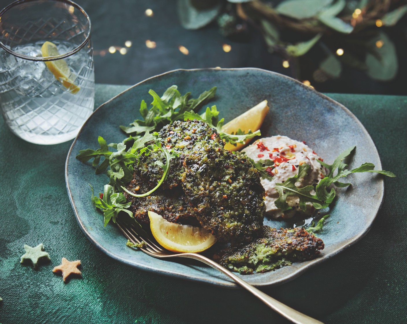 step 4 Meanwhile, make a dip by combining the yogurt (150 g) and houmous (100 g) and seasoning with chilli flakes (1 pinch) to taste. Serve the fritters with the dip, a green salad (to taste) and M&S Remarksable Value lemon (1).