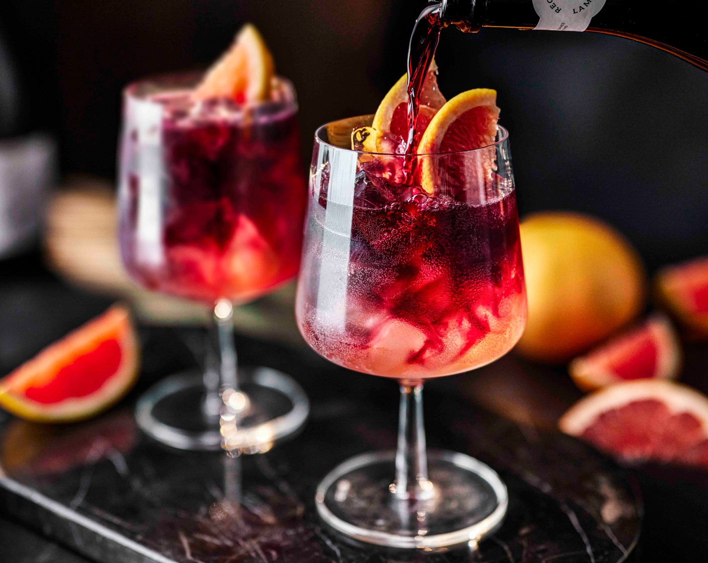 step 1 Add the ice (2 handfuls) to two large spritz glasses. Top up with the Lambrusco (350 ml) and blood orange soda (150 ml), then give it a stir. Add a few drops of orange bitters (10 drops) to each, then gently stir again. Garnish with two slices of grapefruit (1/2).