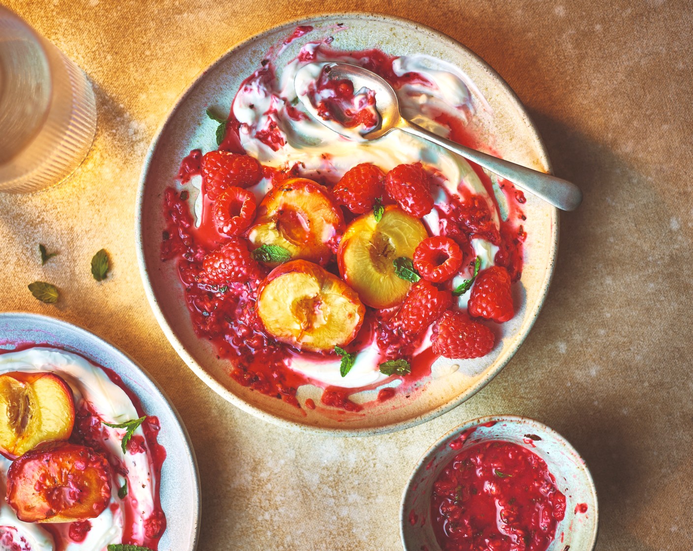 step 3 To serve, spoon the raspberry sauce into 4 platters or shallow bowls. Top with the charred peaches and the remaining M&S Collection sapphire raspberries (50 g) mint and lemon zest. Serve each with a spoonful of Greek yogurt (to taste).