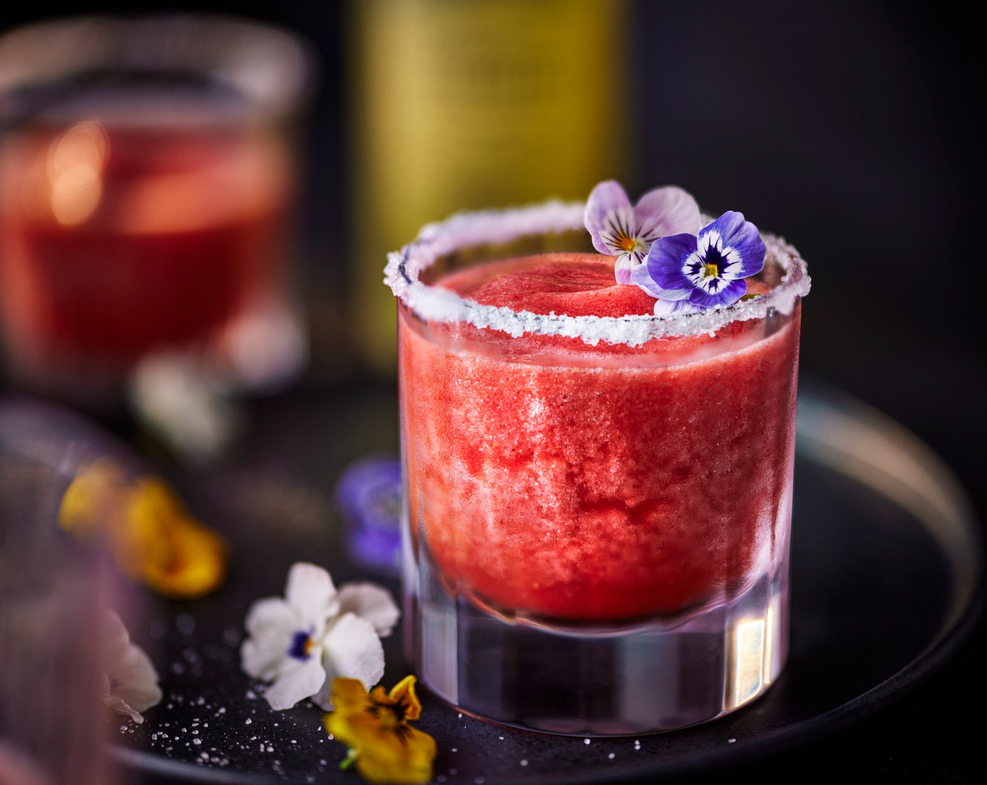 step 3 Pour the cocktail into the prepared glass and garnish with the edible viola flowers (2).