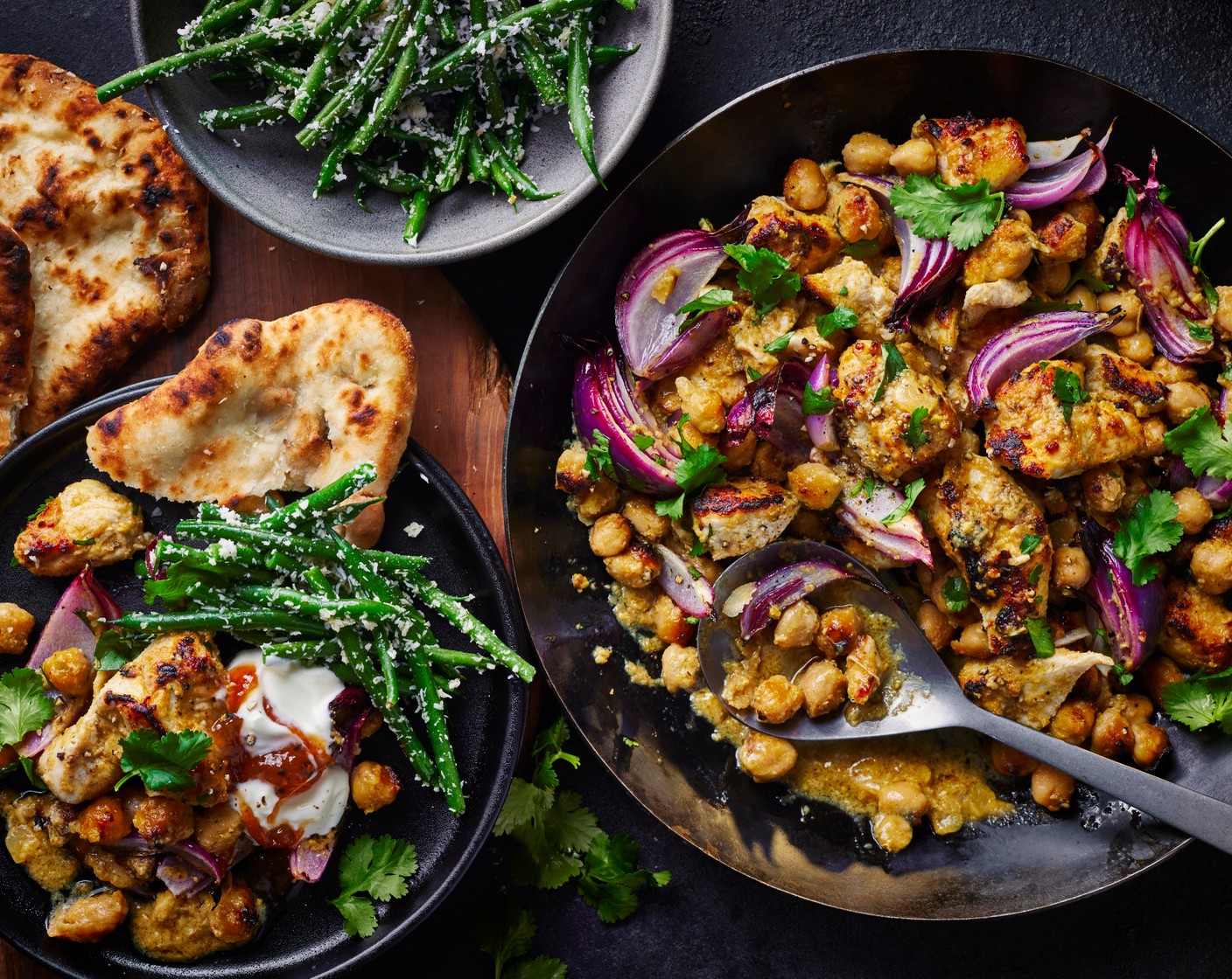 step 5 Divide the chicken and chickpea korma between bowls, top with the remaining coriander (1/2 pack) and serve with the coconut beans, peshwari naan (2), Greek yogurt (to taste) and mango chutney (to taste).