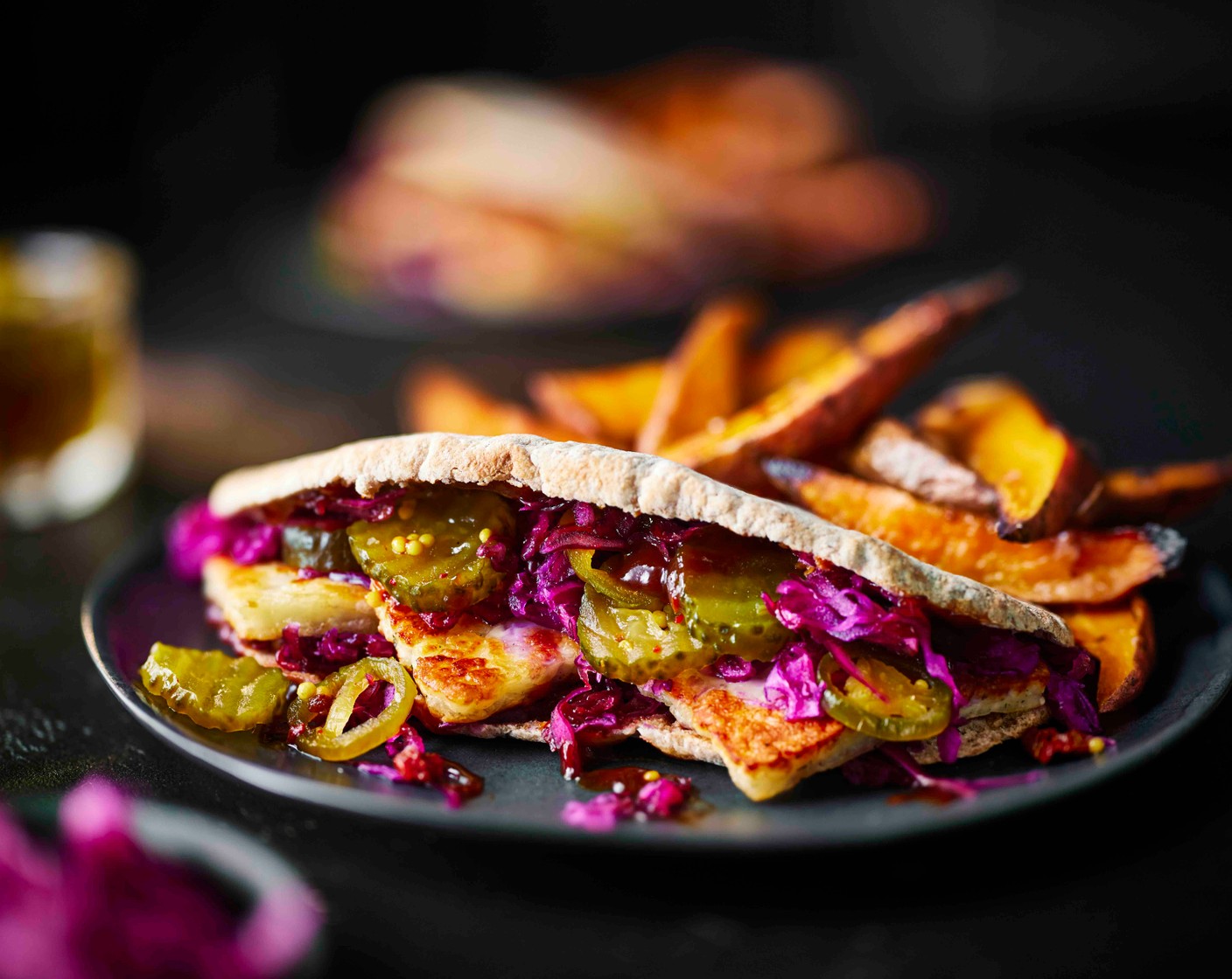 step 5 Cut the pittas (4) open and spread the barbecue sauce (60 g), then fill with halloumi, slaw and pickles (100 g). Serve with the wedges on the side.