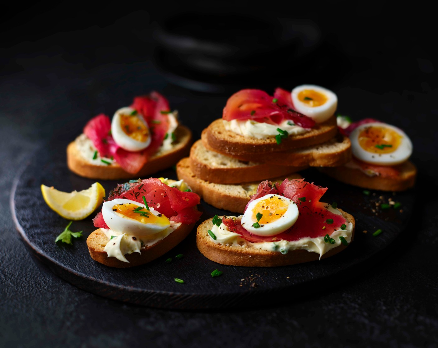 step 4 Top the bruschettine (24) with the lemony crème fraiche, a little smoked salmon and half a quail egg. Finish with some more fresh chives.