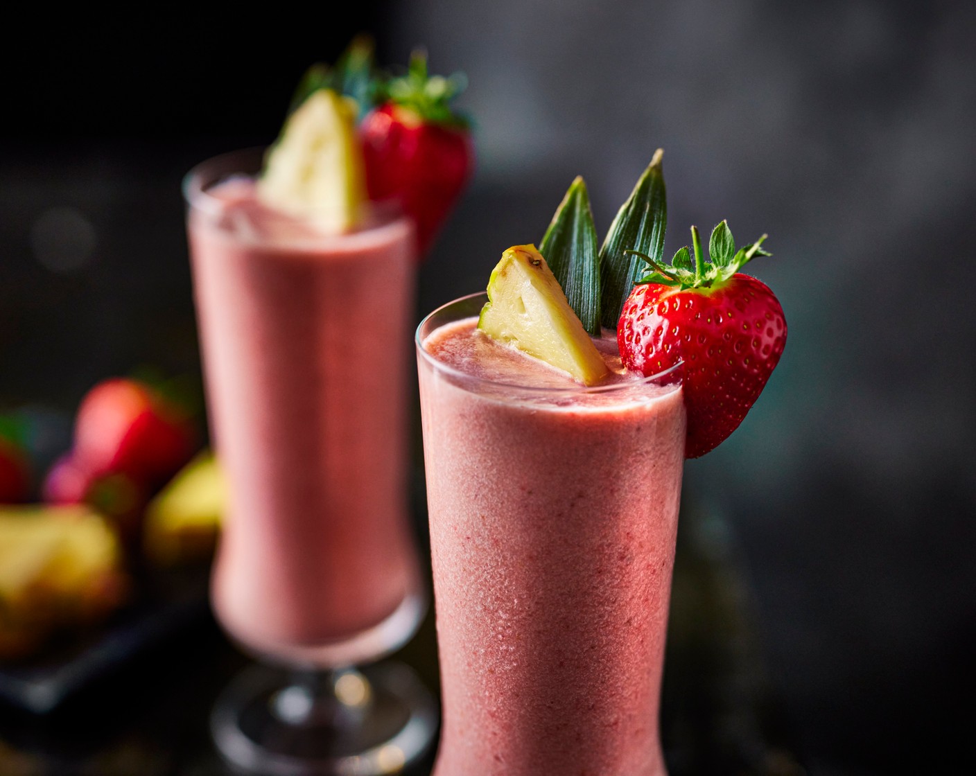 step 2 Pour into a tall glass and garnish with a pineapple wedge (1 wedge) and a strawberry (1).