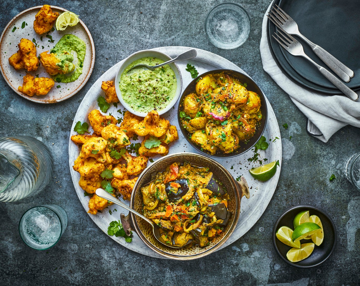 step 9 Serve the aubergine curry in warmed bowls with the aloo sabzi and the pakoras and chutney on the side.