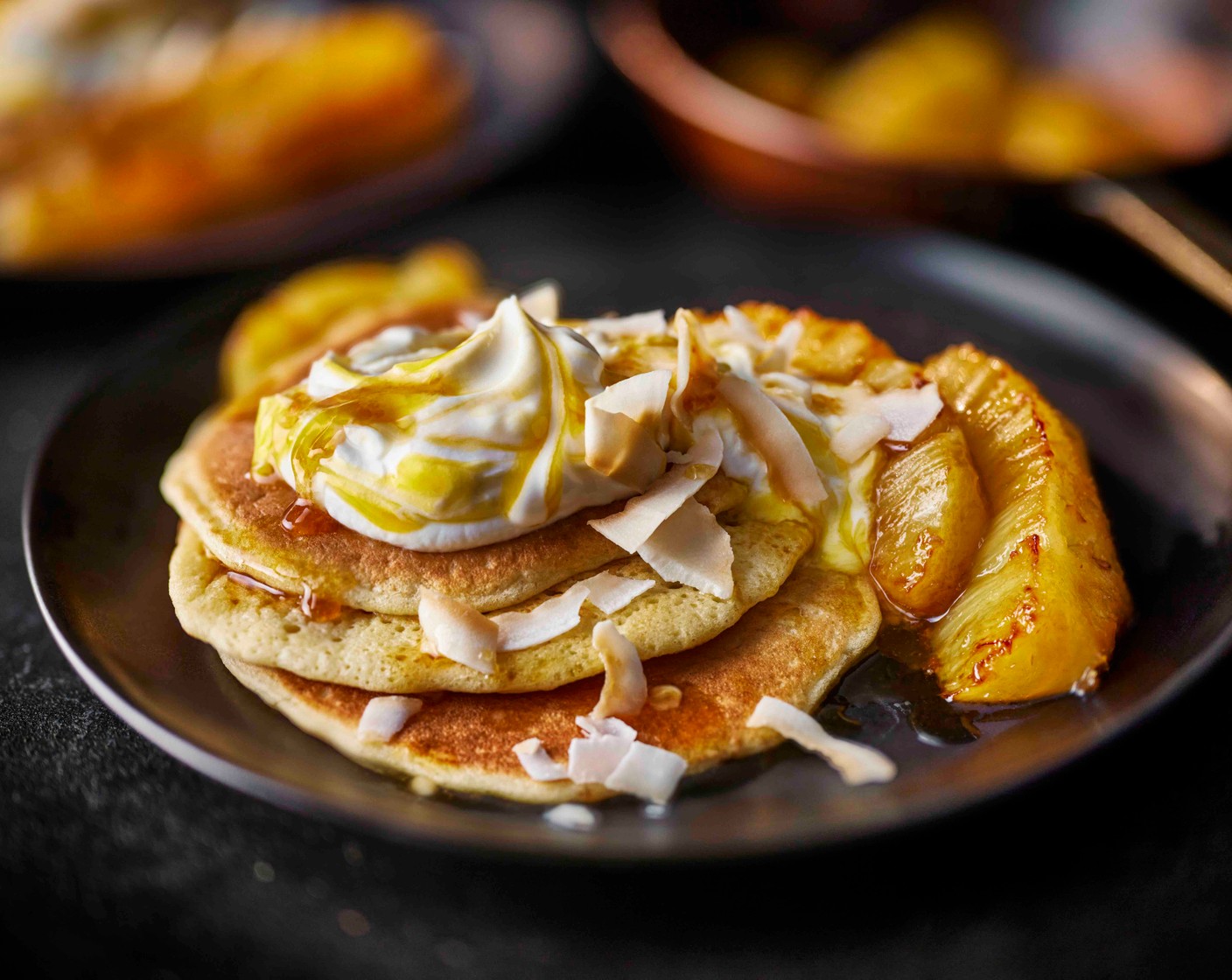 step 6 Serve the pancakes with the caramelised pineapple, a spoonful of yogurt (4 tbsp) and the roasted coconut flakes (1 tbsp).