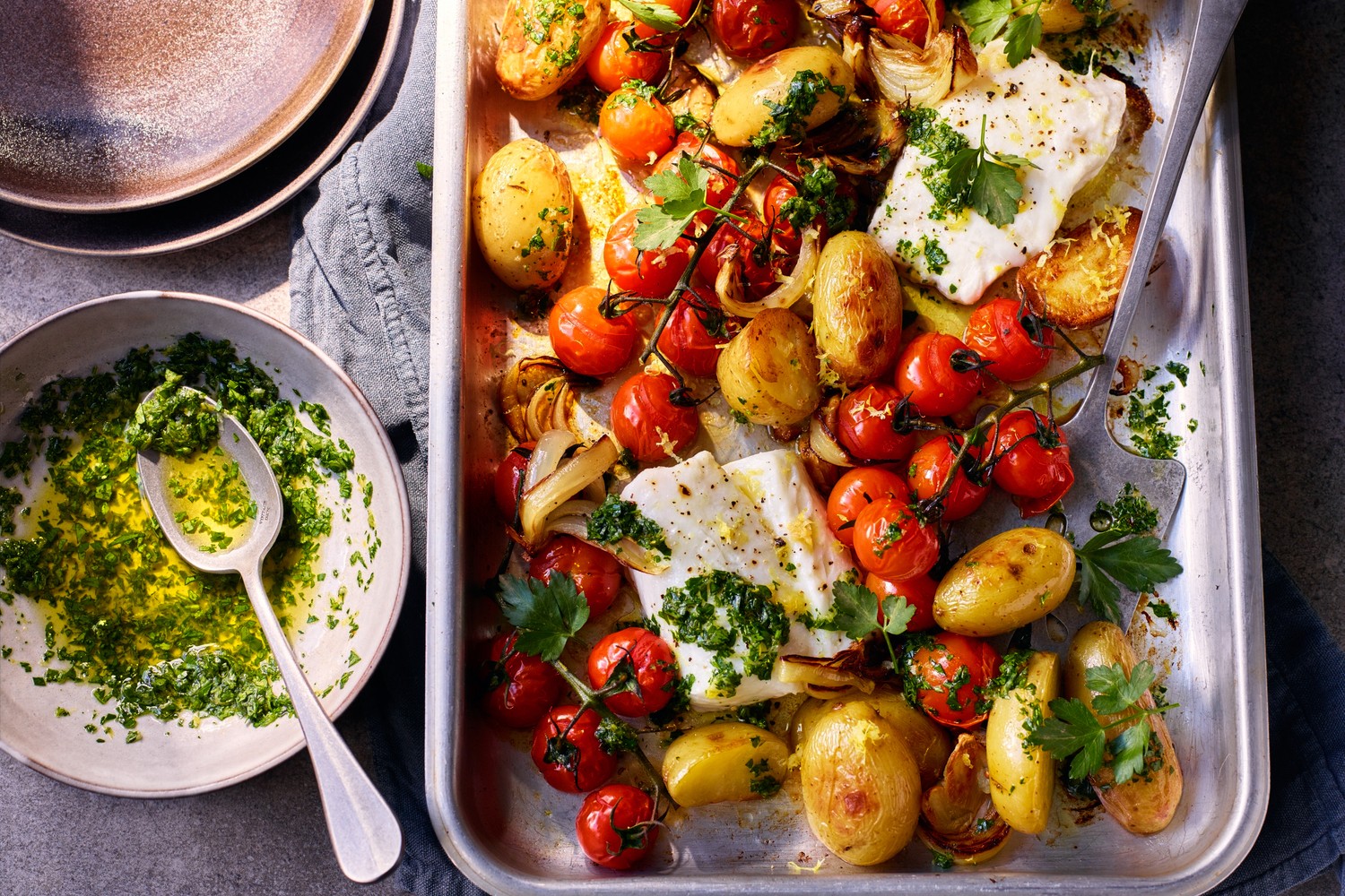 Cod, new potato and roasted tomato traybake with gremolata