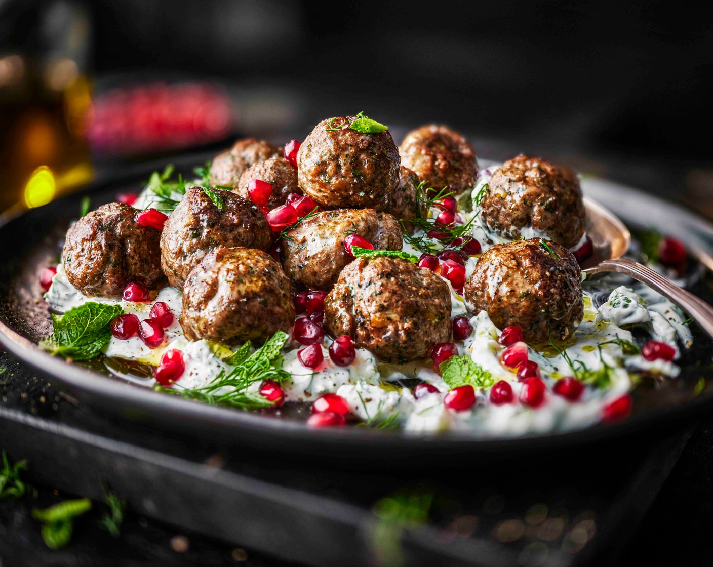 step 4 Spoon the tzatziki onto a serving plate and top with the hot meatballs. Scatter over the pomegranate seeds (1 handful) and extra mint, then drizzle with a little more olive oil (as needed) to finish. Serve immediately.