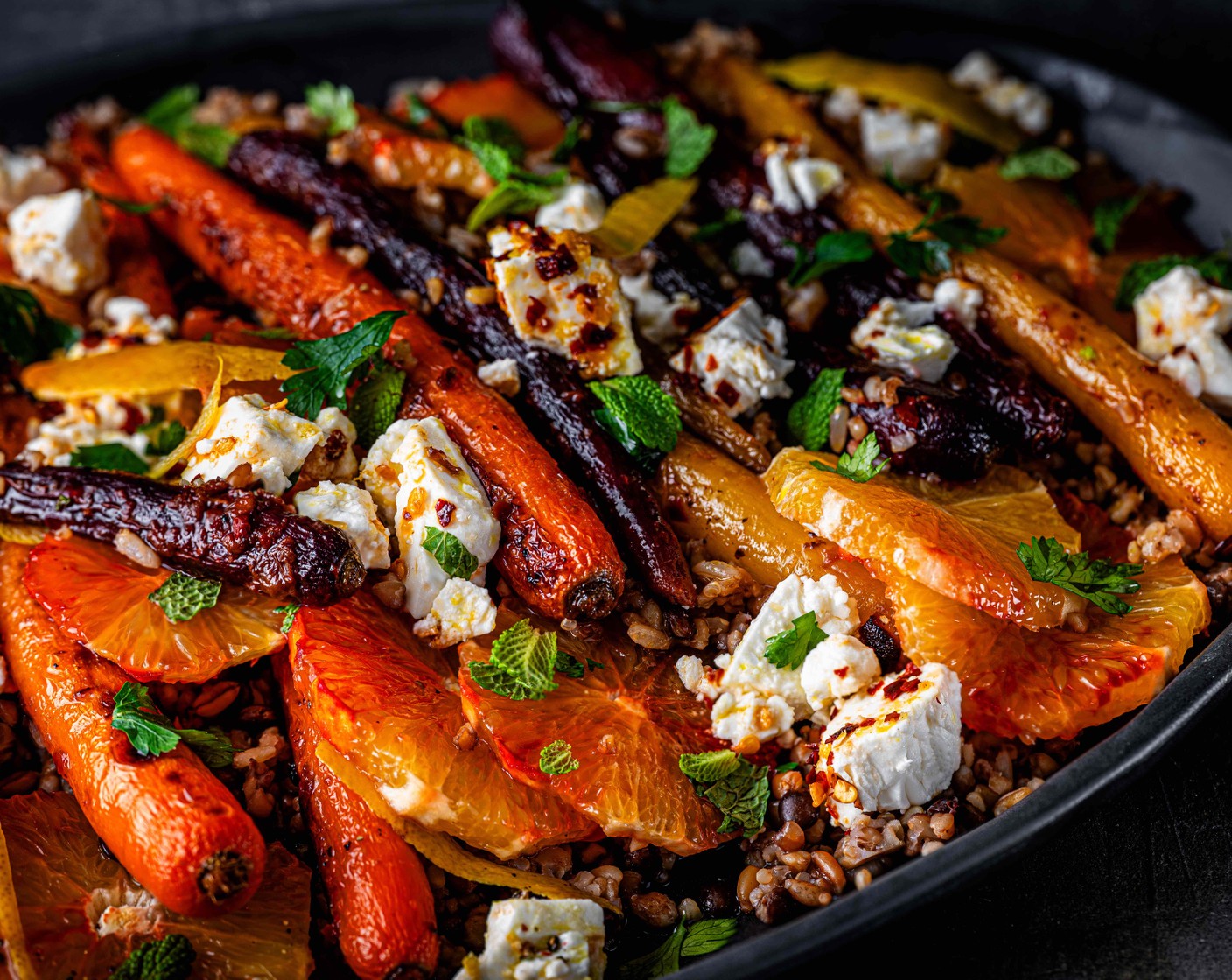 step 7 Tumble the grains onto a big platter and top with the roasted carrots and orange slices. Spoon over the remaining dressing. Crumble over the feta.