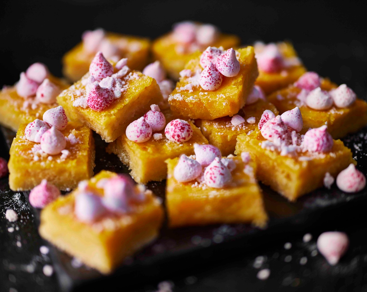 step 7 Lift out of the tin, cut into 16 bars, dust with icing sugar and finish with raspberry ripple meringue sprinkles (as needed).