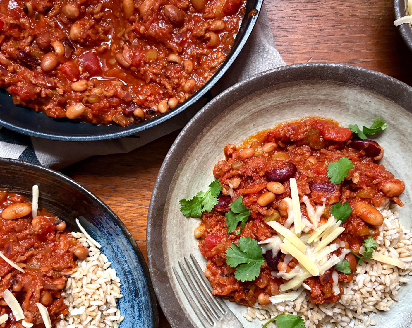 step 6 Heat the rice (2 pouches) in the microwave according to the pack instructions. Serve the chilli with the rice and a little bit of cheese (80 g) on top, if you like, plus some fresh coriander (as needed).