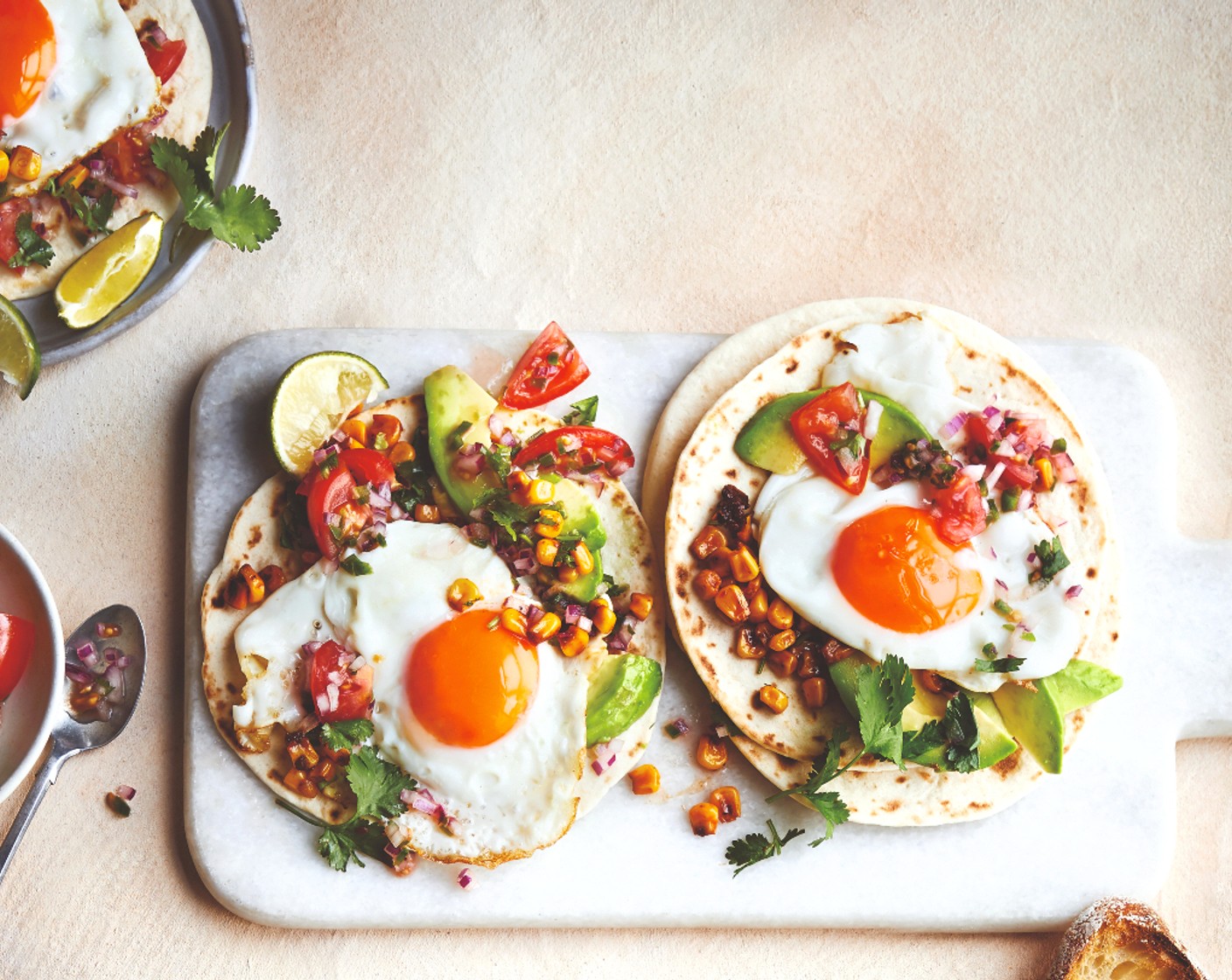 step 5 Serve the warmed tacos with the fried eggs, salsa, charred sweetcorn, sliced avocado (1), more lime wedges and fresh coriander.