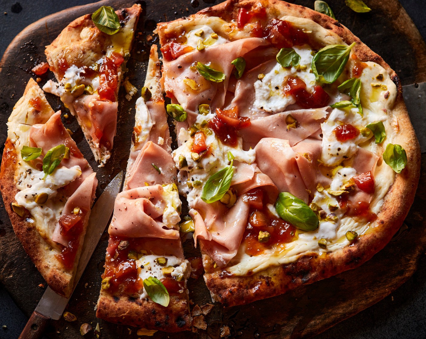 step 3 Top the warm pizza with the mortadella (2 slices) and burrata, followed by a scattering of pistachios (25 g) and basil (25 g). Drizzle over the peach and jalapeño relish (1 tbsp) before slicing.