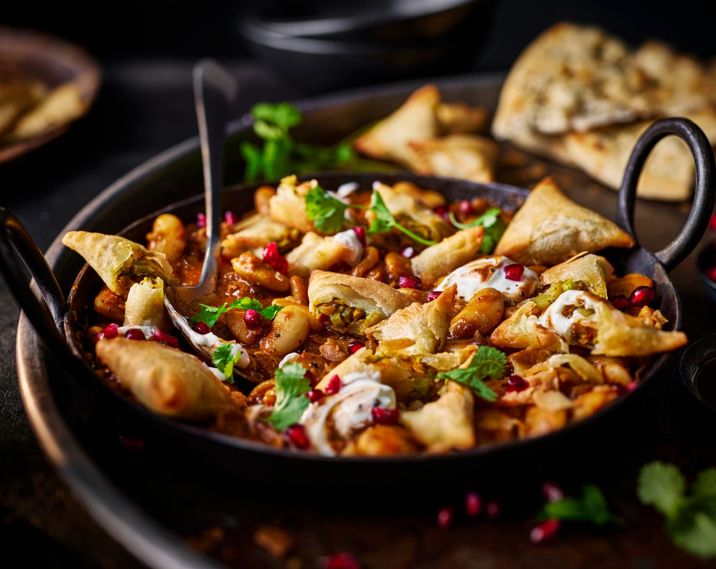 step 8 Serve the butter bean curry in bowls. Smash or break the cooked samosas into rough chunks and arrange on top of the curry, along with the yogurt (120 g), tamarind sauce, pomegranate rubies (200 g) and coriander (15 g). Scoop up with naan for a heartier meal.