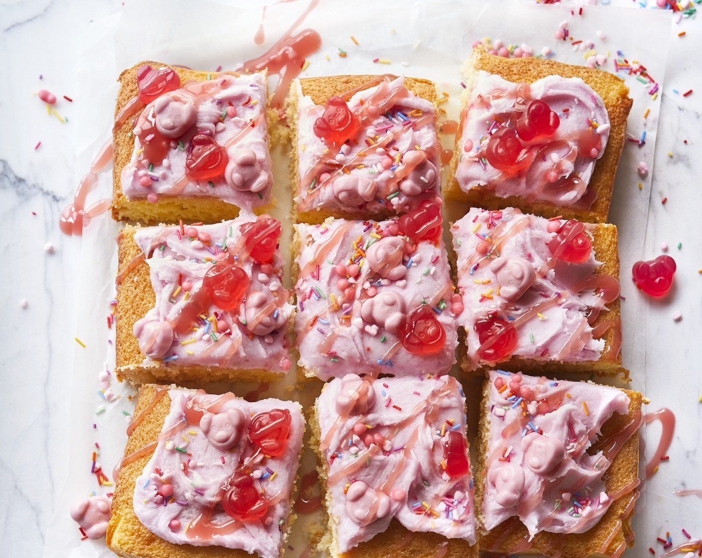 step 5 Turn out of the tin then spread over the icing and decorate with Percy Pig sweets (as needed), Percy Pig party sprinkles (as needed) and M&S strawberry sauce (as needed).