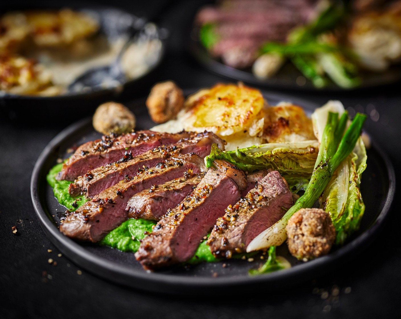 step 6 Divide the steaks between your plates, then serve alongside the creamy dauphinoise potatoes, pea purée, roasted spring onions, shaved gem lettuce and crispy garlic mushrooms.