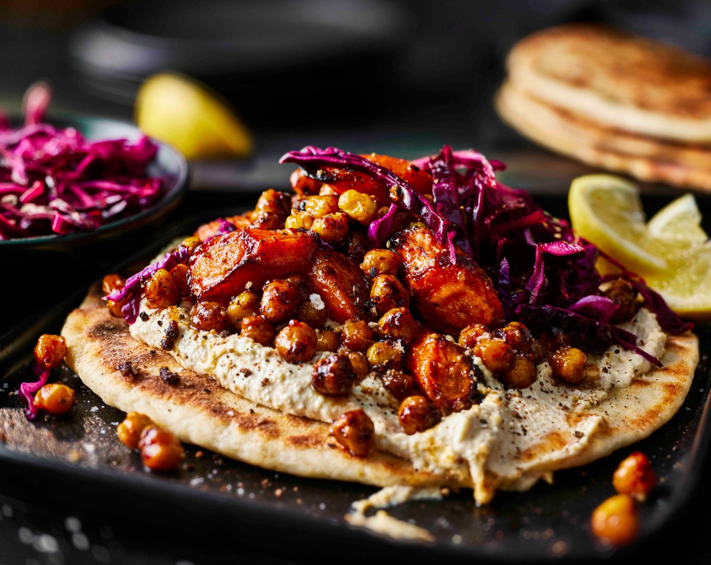 step 6 Spread the houmous (1 pot) over the warm flatbreads, then top with the shawarma-spiced carrots and chickpeas. Finish with the lemony red cabbage and serve immediately.