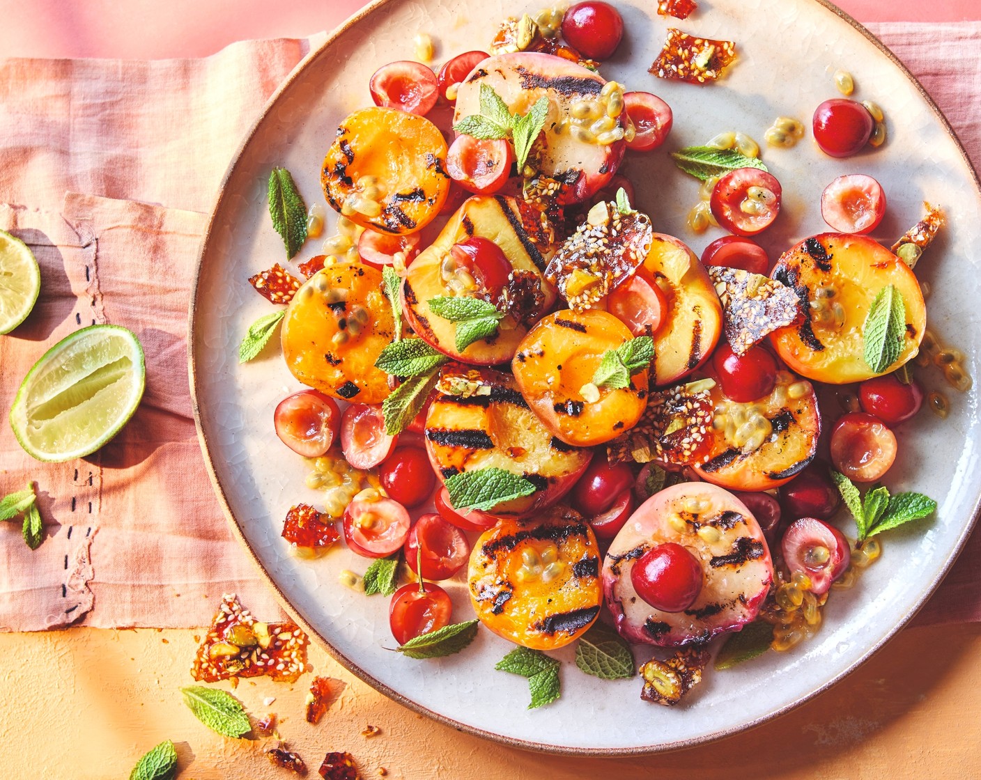 step 4 Arrange the charred fruit on a large platter along with the torn cherries (150 g). Drizzle over the passion fruit salsa. Roughly chop up half the brittle and scatter over the fruit along with the mint leaves (2 sprigs).