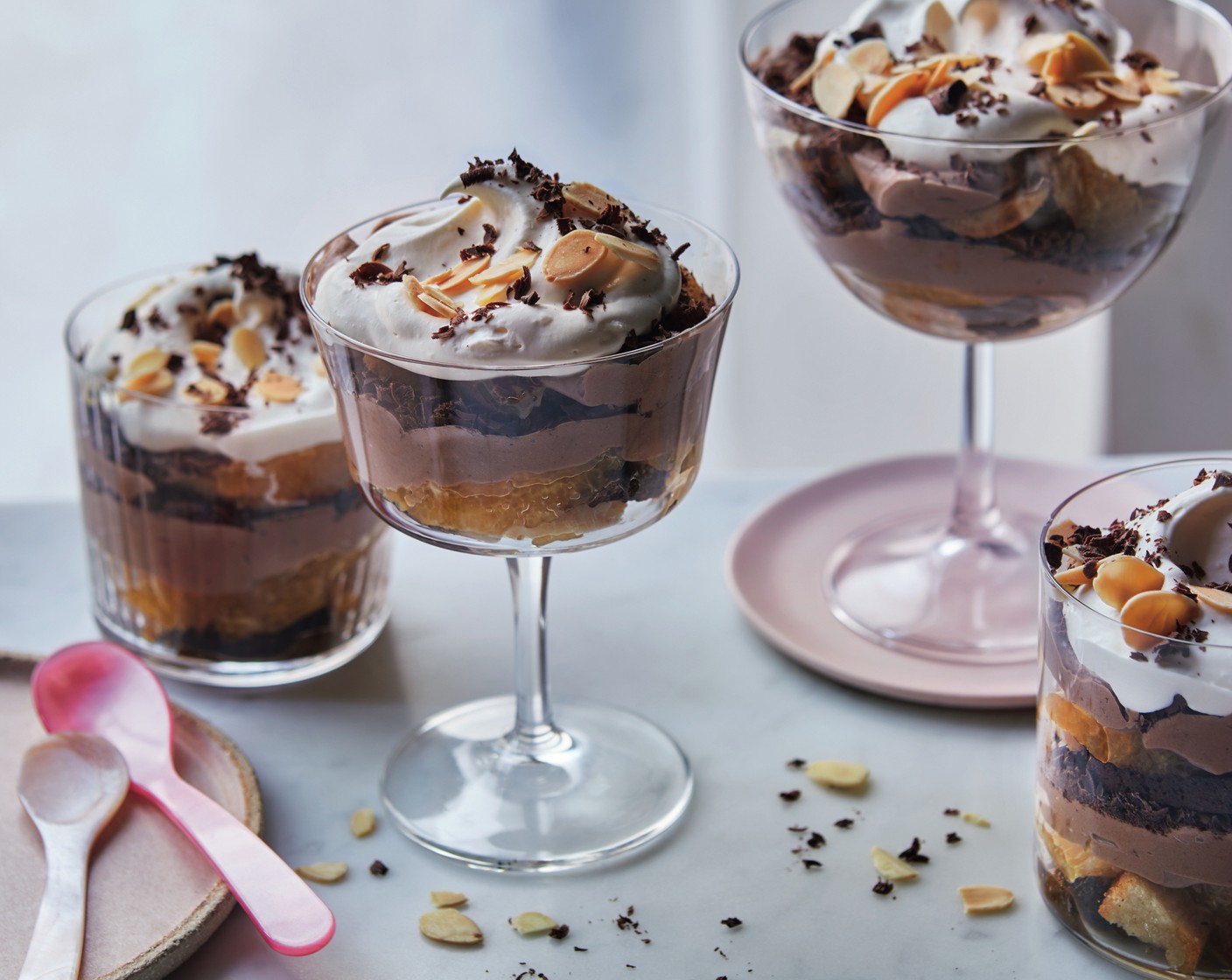step 5 Combine the double cream (300 ml) with the vanilla extract (1 tsp), the remaining mascarpone (125 g), 1 tbsp icing sugar (1 tbsp) and any leftover boozy orange juice and whisk to soft peaks. Spoon the cream over the top of each trifle, then scatter with the remaining grated chocolate (25 g) and the flaked almonds (25 g).
