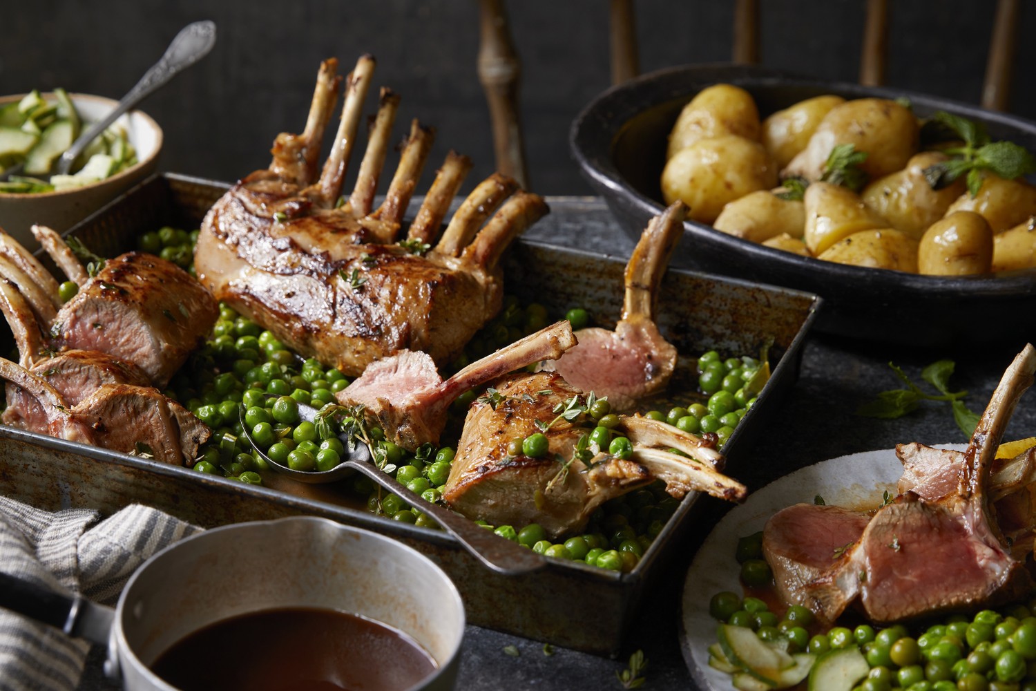 Rack of lamb with braised peas, new potatoes, pickled cucumber and lamb sauce