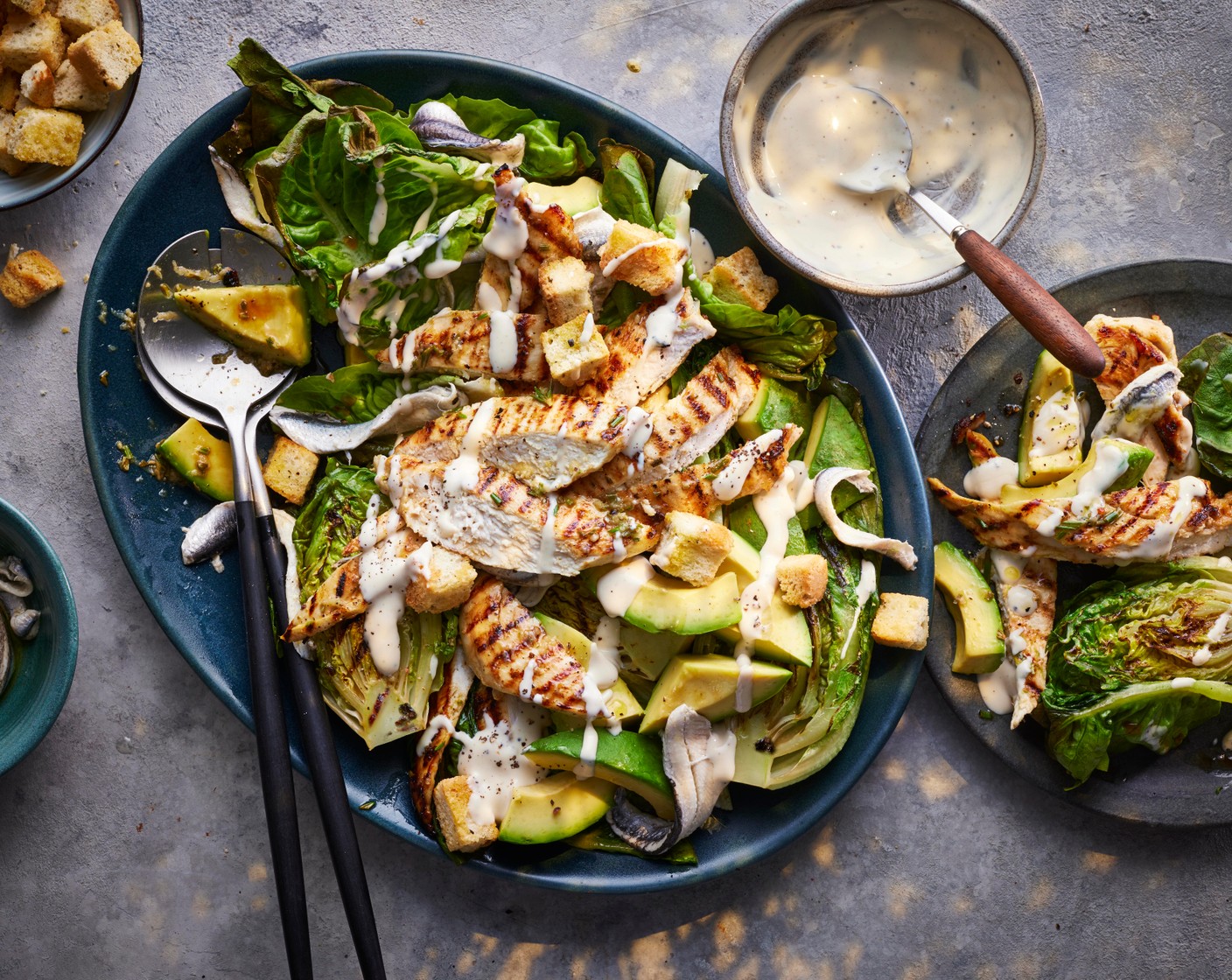 step 4 Arrange the lettuce on a serving platter and top with the chicken, avocado (1), anchovies (70 g) and crouton (1 pack). Pour over the dressing (2 tbsp) and serve.
