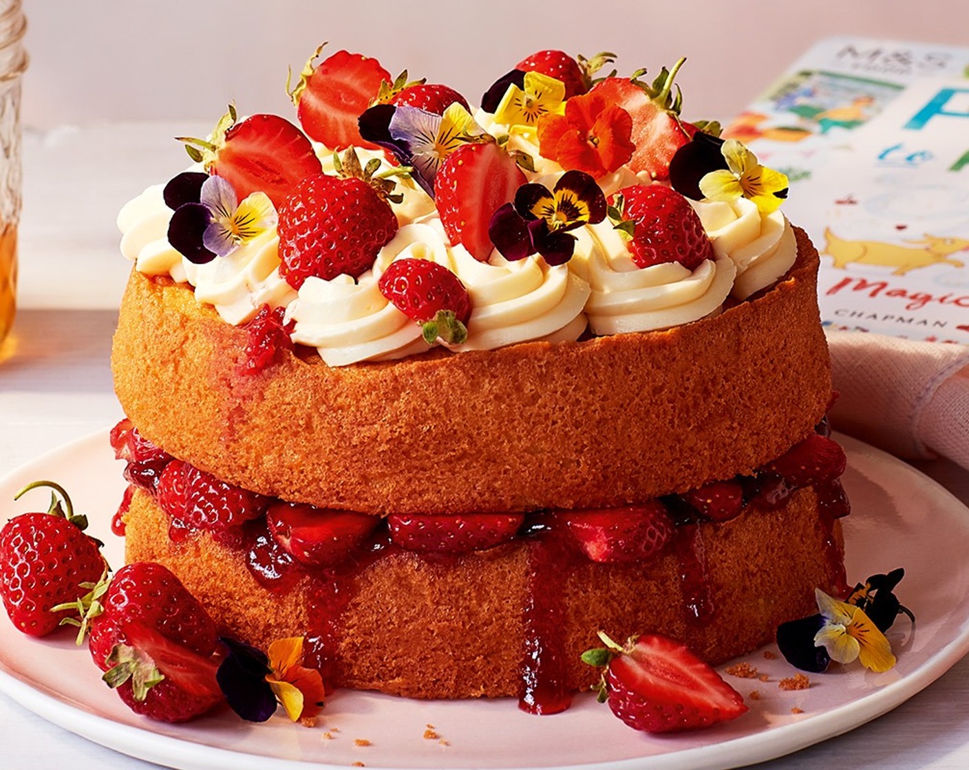 step 8 Carefully place the second cake on top of the first one. Cover the top of it with the honey buttercream and the remaining strawberries.