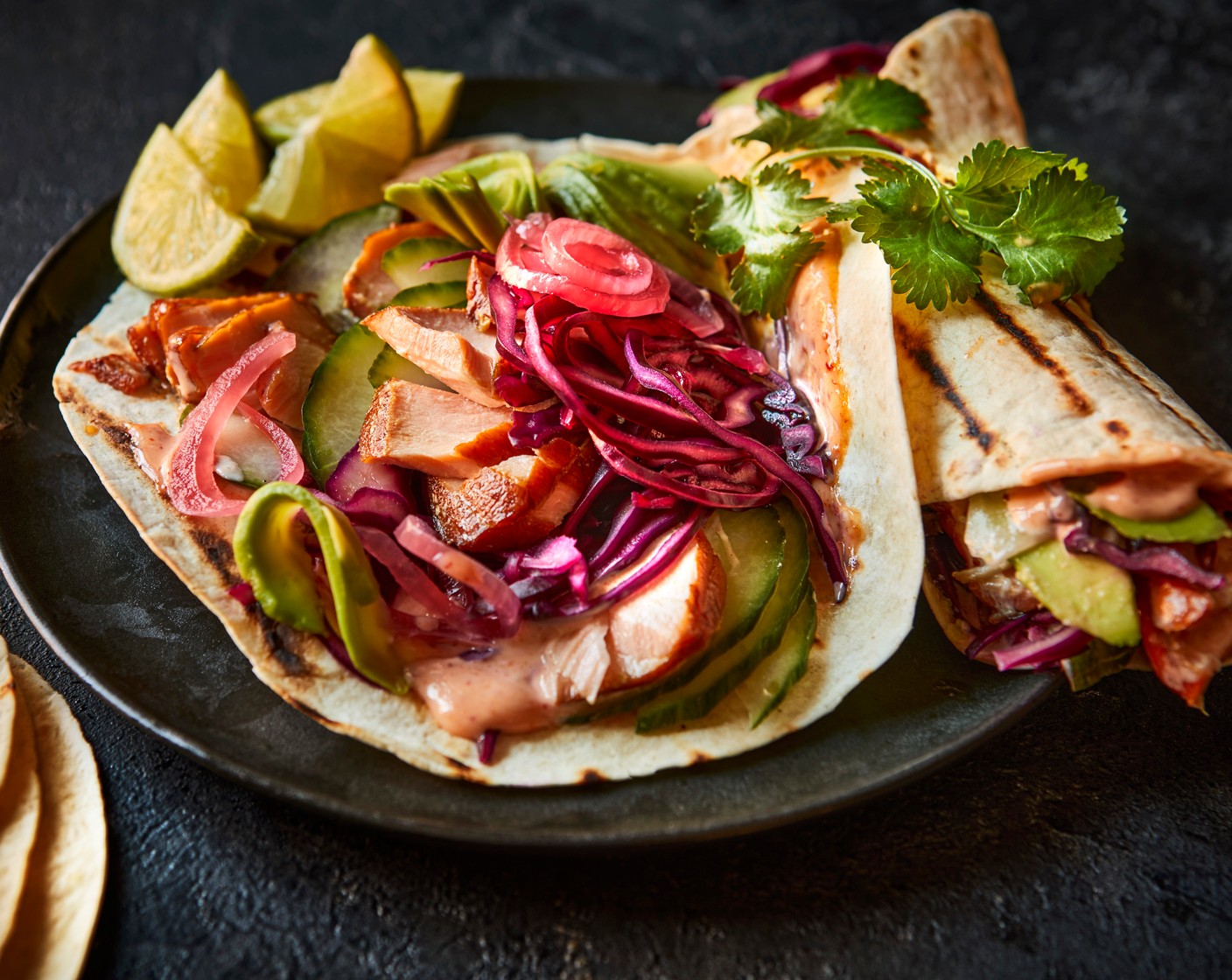 step 4 In the centre, scatter over the flaked salmon (1 pack), pickled cabbage, cucumber (1/2), avocado (1) and pickled red onions (1 tbsp). Fold the tortilla over the filling, slice in half and dig in. 
Serve with extra pickled cabbage, if you’d like.