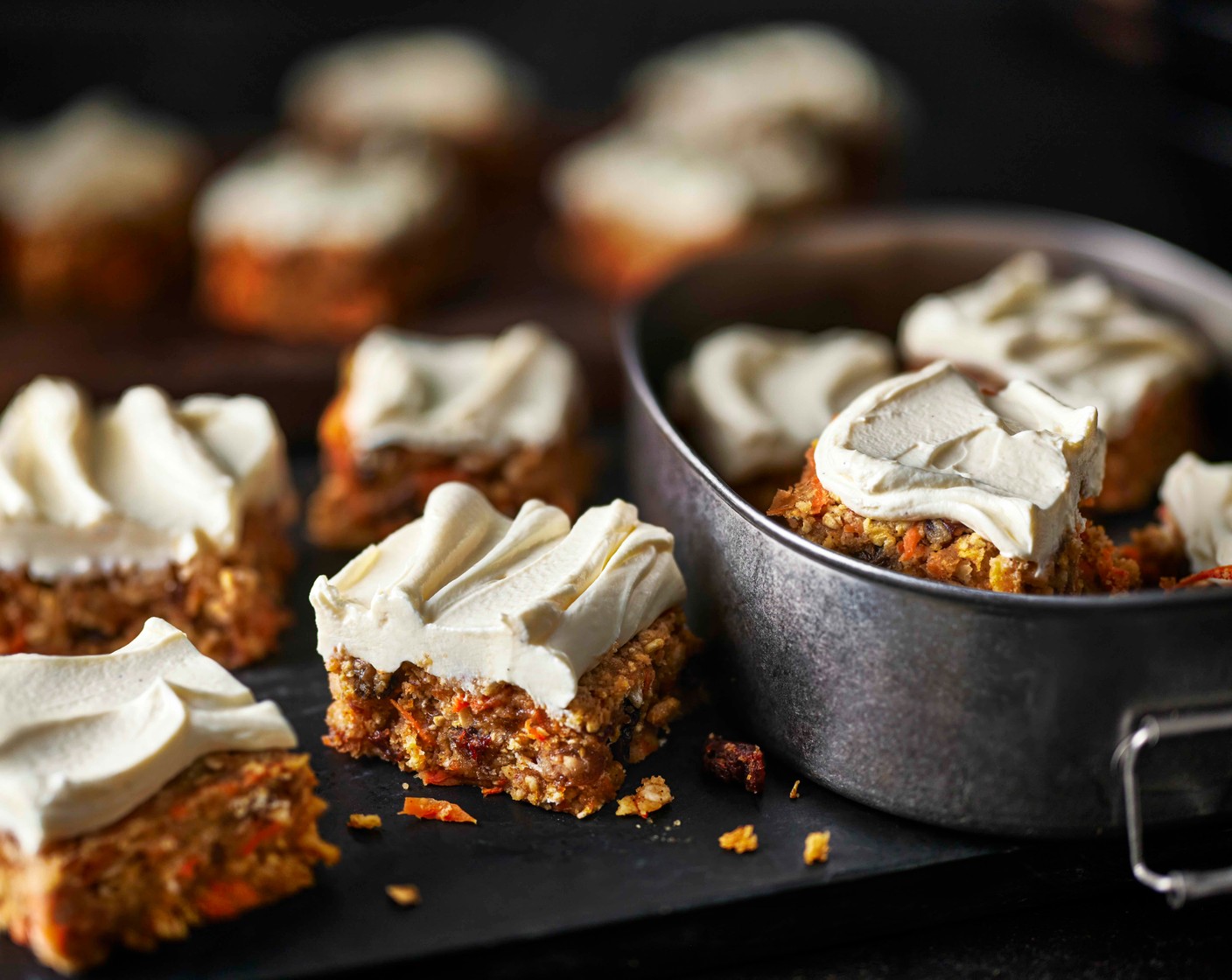 step 7 Turn out the chilled carrot cake slab onto a clean chopping board. Spread the topping evenly over the surface. Return to the fridge for at least 3 hours until set, then cut into 16 bars and serve.