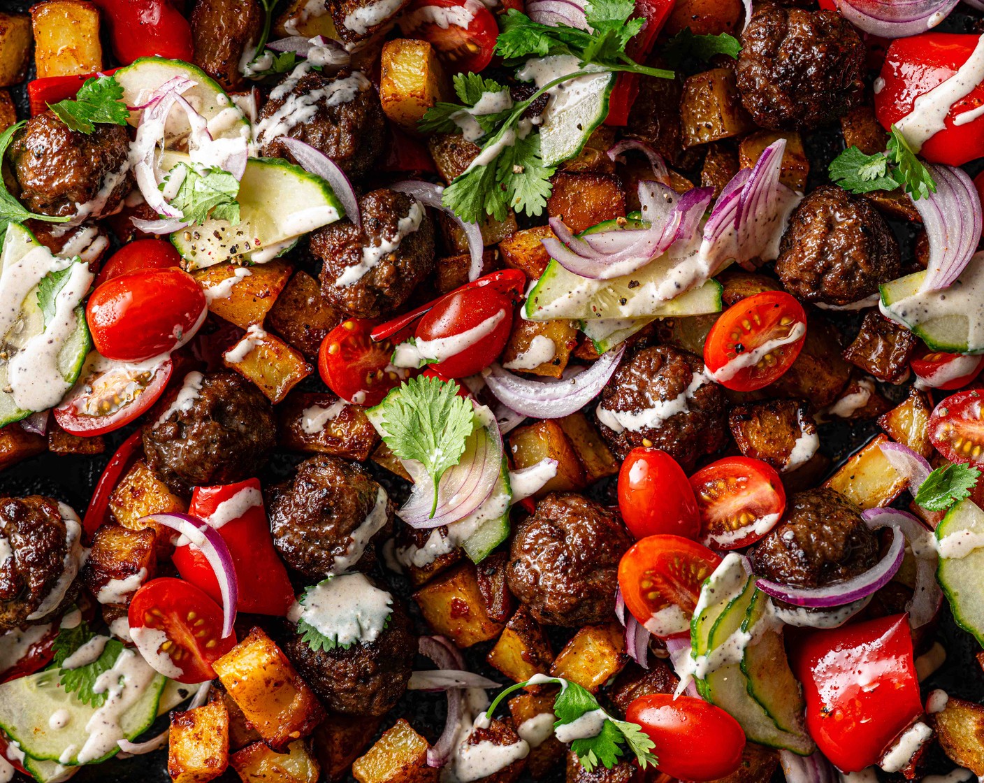 step 5 Scatter the cooked meatballs and potatoes with the chopped coriander (10 g), then top with the salad, tahini sauce and sumac (1/2 tsp).