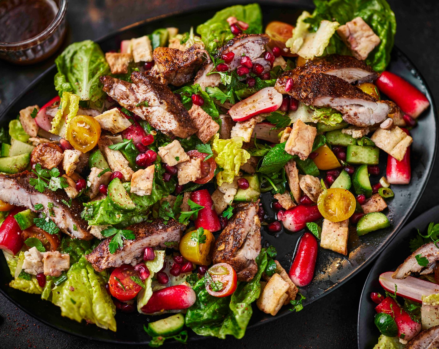 step 5 Slice the chicken and toss through the salad along with most of the crispy pitta chips. Arrange on a big platter or in a serving bowl and drizzle with the remaining dressing. Scatter with more fresh herbs and top with the pomegranate rubies (2 tbsp) and the remaining pitta chips. Serve with the crunchy pitta chips on top and an extra sprinkling of sumac, if you like.