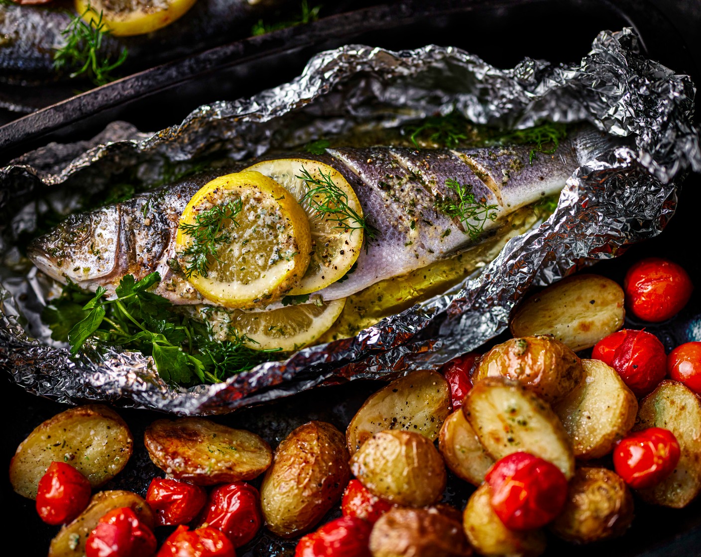 step 6 Scatter the fish with some extra herbs and serve with the potatoes and tomatoes, along with a spoonful of juices from the foil.