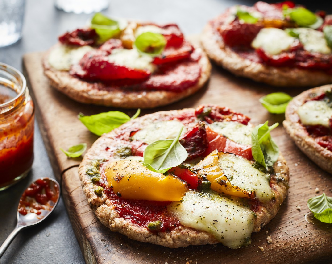 step 5 Once cooked, scatter the basil (1 handful) over the pizzas and finish off with a drizzle of olive oil (2 tbsp).