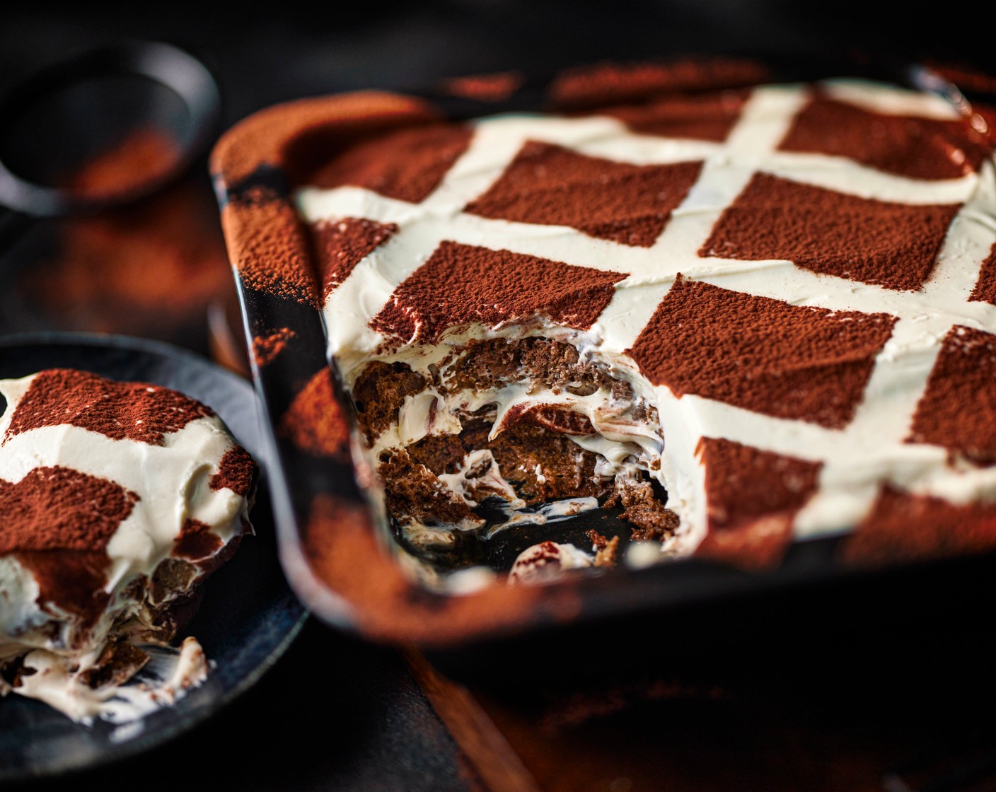 step 6 Cut six 1.5cm strips of paper and lay across the top of the tray diagonally to create a criss-cross stencil shape across the top of the tray. Dust with the cocoa powder (1 tbsp) to create squares.