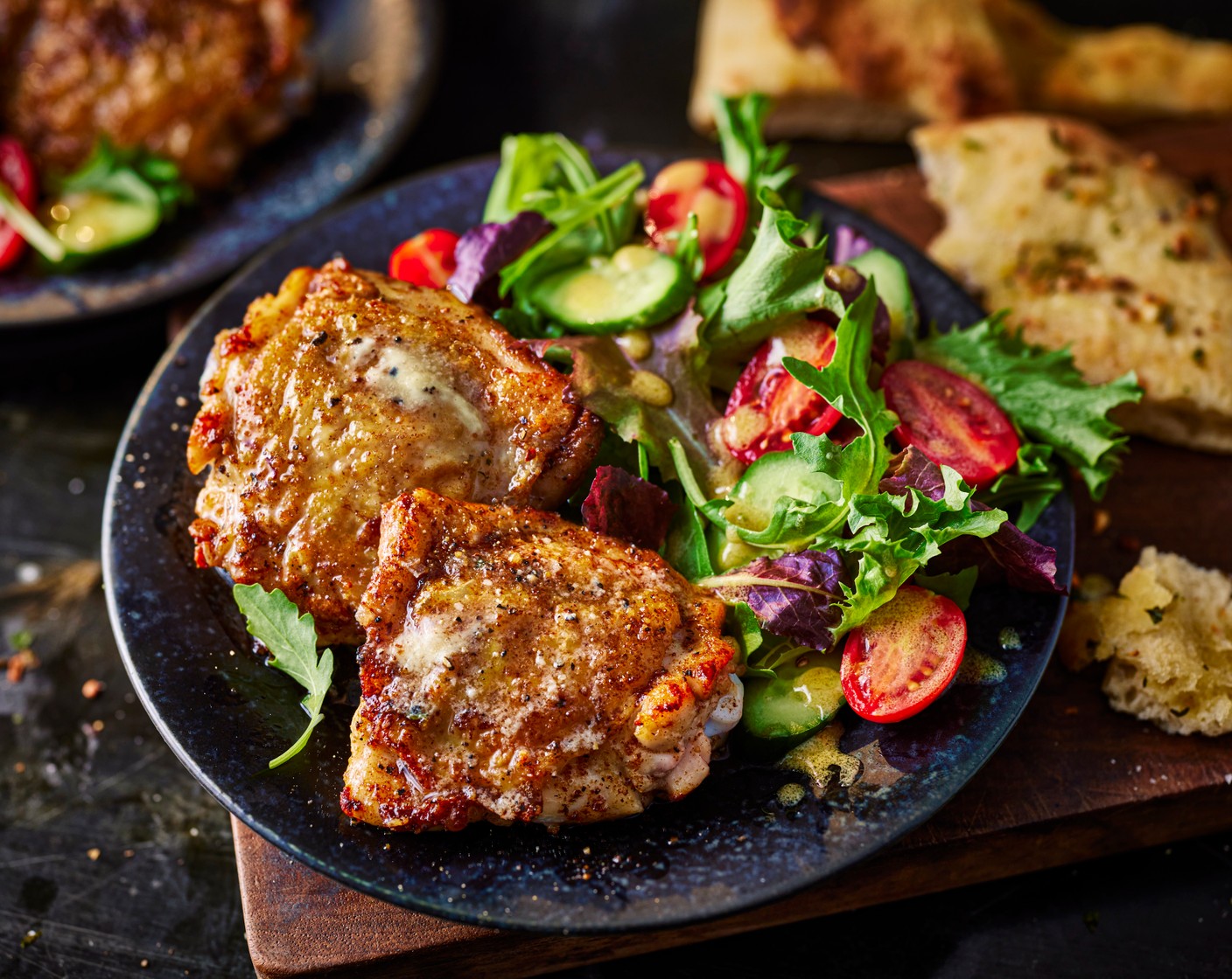 step 6 Serve the chicken on plates and pour over the juices from the pan. Serve with the salad and garlic flatbread.