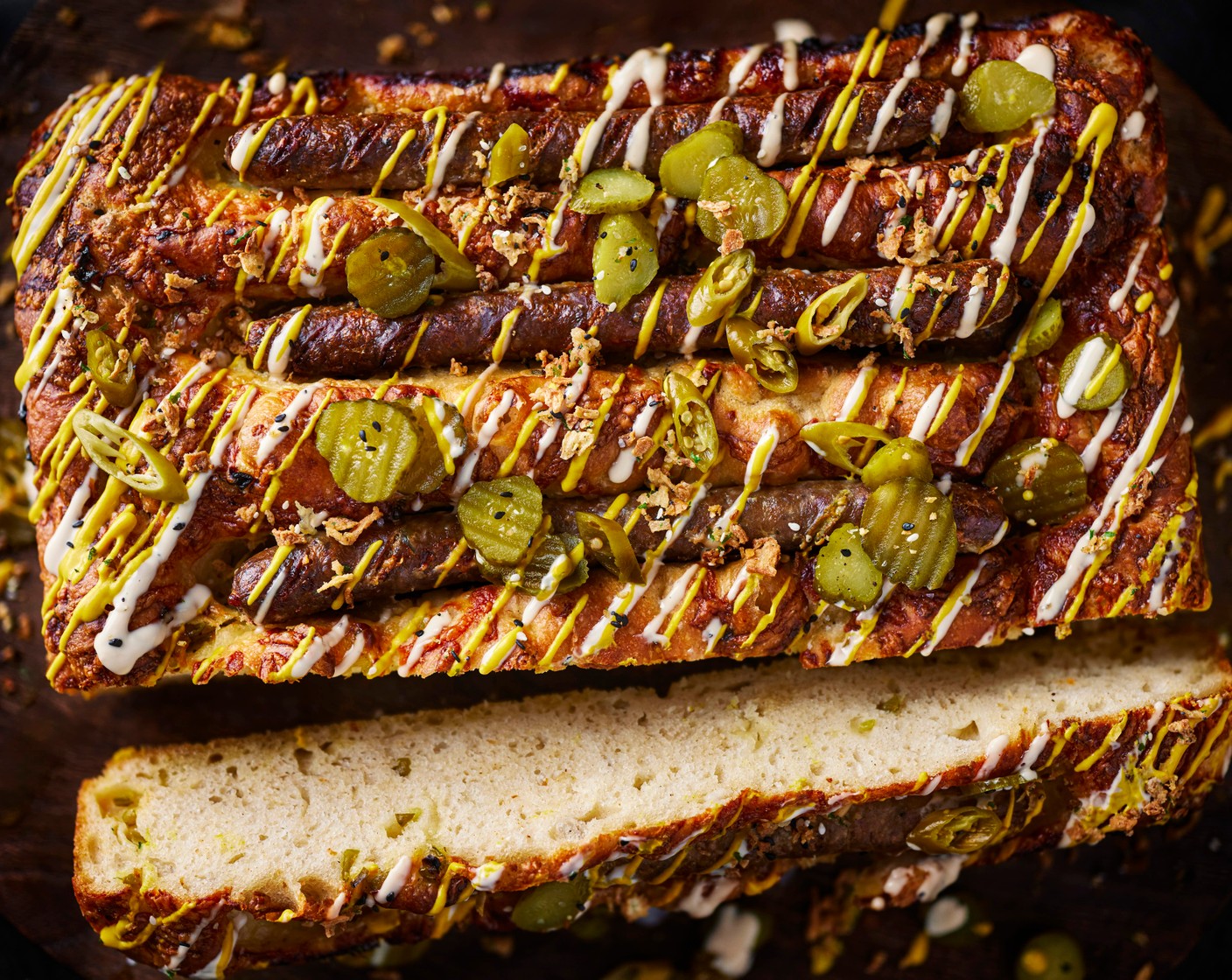 step 7 Remove from the oven and top with the cheese (50 g) immediately. Allow to cool slightly before topping with pickles (to taste), mustard (to taste), campfire mayo (to taste) and Top That seasoning (to taste). Slice into 4 long hot dogs and serve.