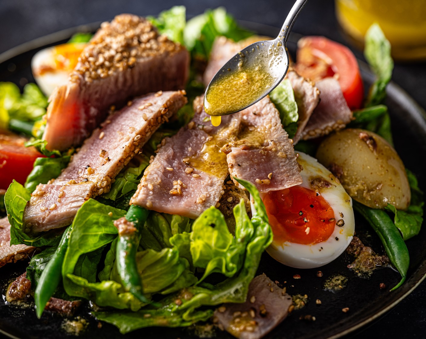 step 6 Toss the potatoes, green beans, tomatoes (2) and lettuce (1 head) with the dressing, and serve in bowls topped with the halved eggs and sesame-crusted tuna steaks.