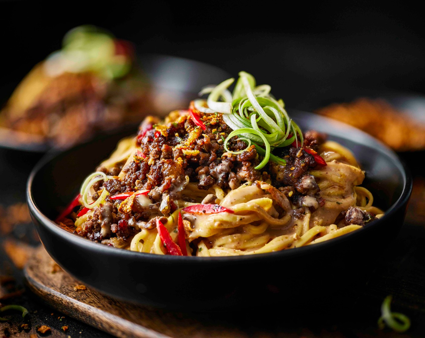 step 6 Add the noodles to four bowls, then evenly top the noodles with the beef mince. Scatter over the remaining spring onions and chilli and finish with ½ tbsp of the stir fry chilli topper (2 tbsp) on each bowl.