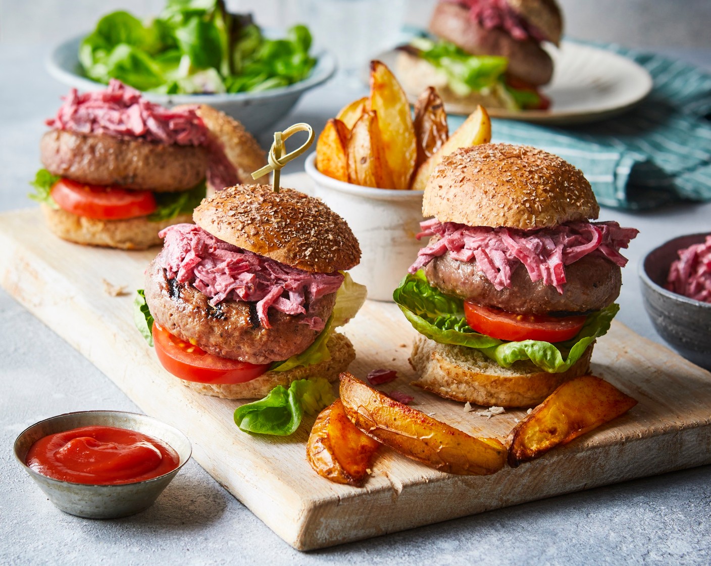 step 4 Slice open the rolls (4). Place a burger into each and top with the lettuce (2), tomatoes (2) and slaw (180 g). Serve with the side salad and the wedges.